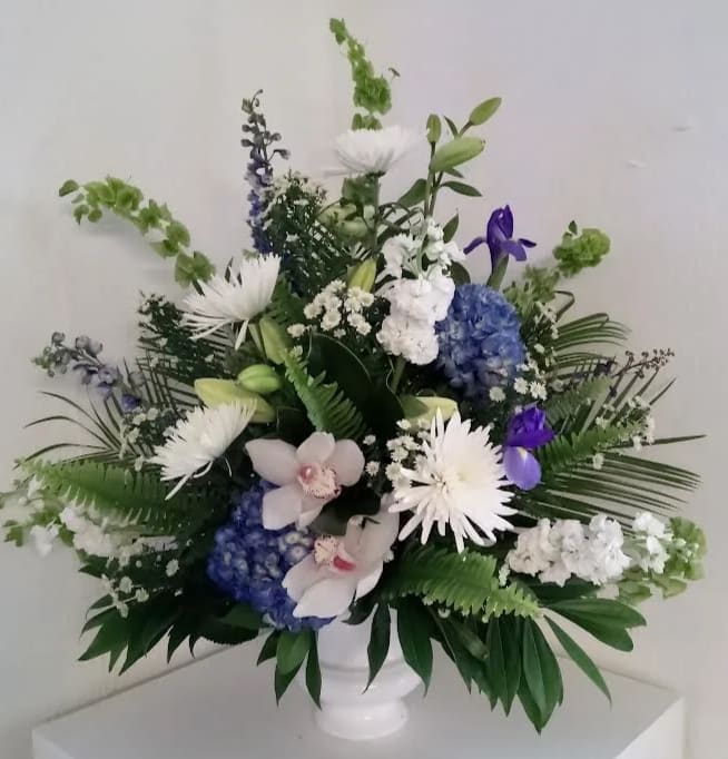White and blue floral arrangement in a white vase