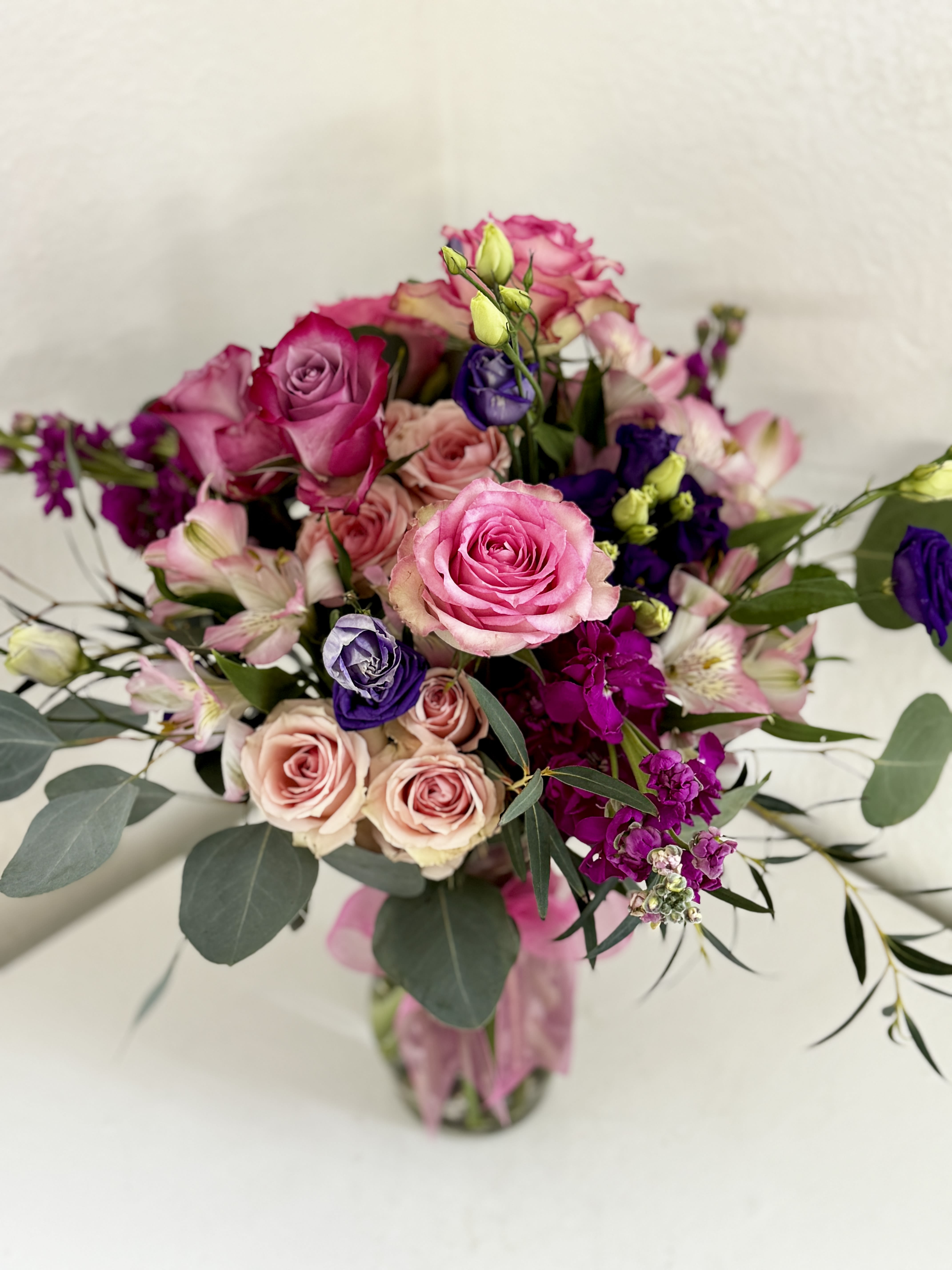 Pink and purple rose bouquet in a glass vase