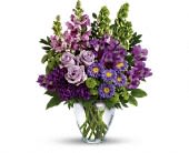 Lavender Charm - A soothing sea of lavender, this beautiful bouquet blends luxurious roses and alstroemeria with playful snapdragons and bells of Ireland. It's a charming, cheerful gift for any occasion!  This lovely bouquet features lavender roses, purple alstroemeria, purple carnations, lavender matsumoto asters, green button spray chrysanthemums, lavender snapdragons, bells of Ireland, huckleberry and lemon leaf. Delivered in a clear glass vase.  Approximately 14 1/2" W x 17 1/2" H  Orientation: One-Sided  As Shown : TEV42-3A Deluxe : TEV42-3B Premium : TEV42-3C