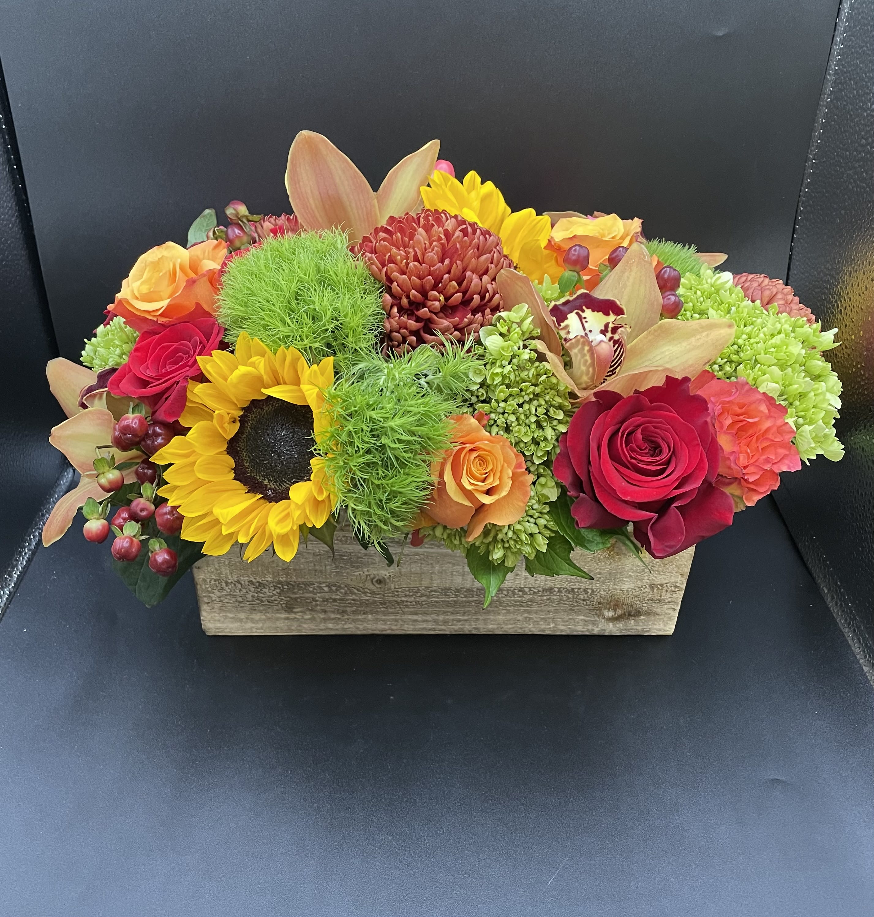 Colorful mixed flower arrangement in a rectangular wooden box