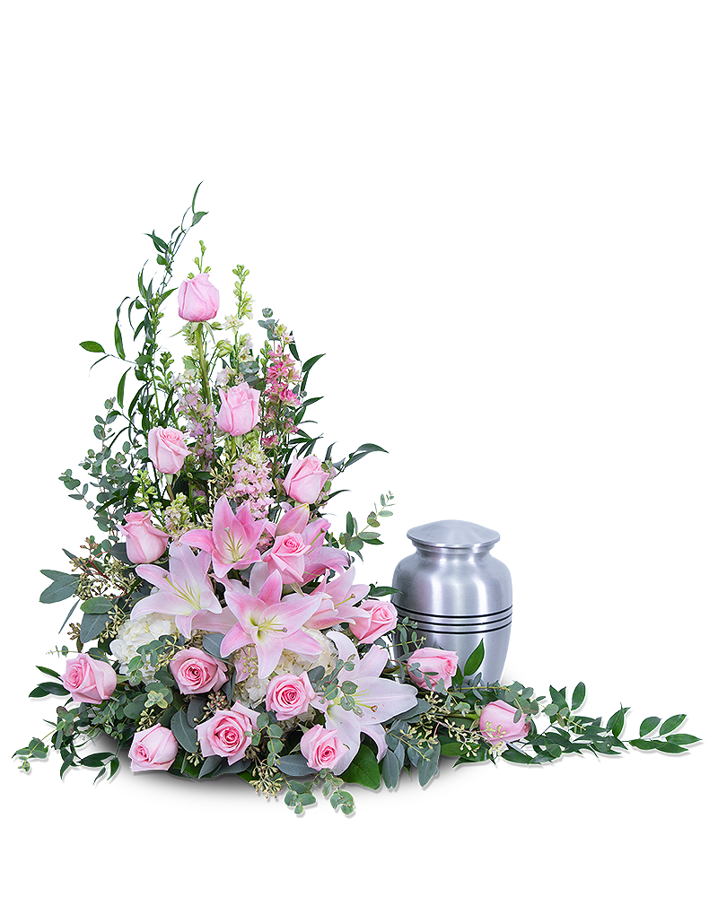 Pink lilies and roses arranged beside a silver cremation urn.