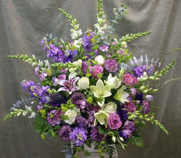 Large purple and white floral arrangement with lilies and roses