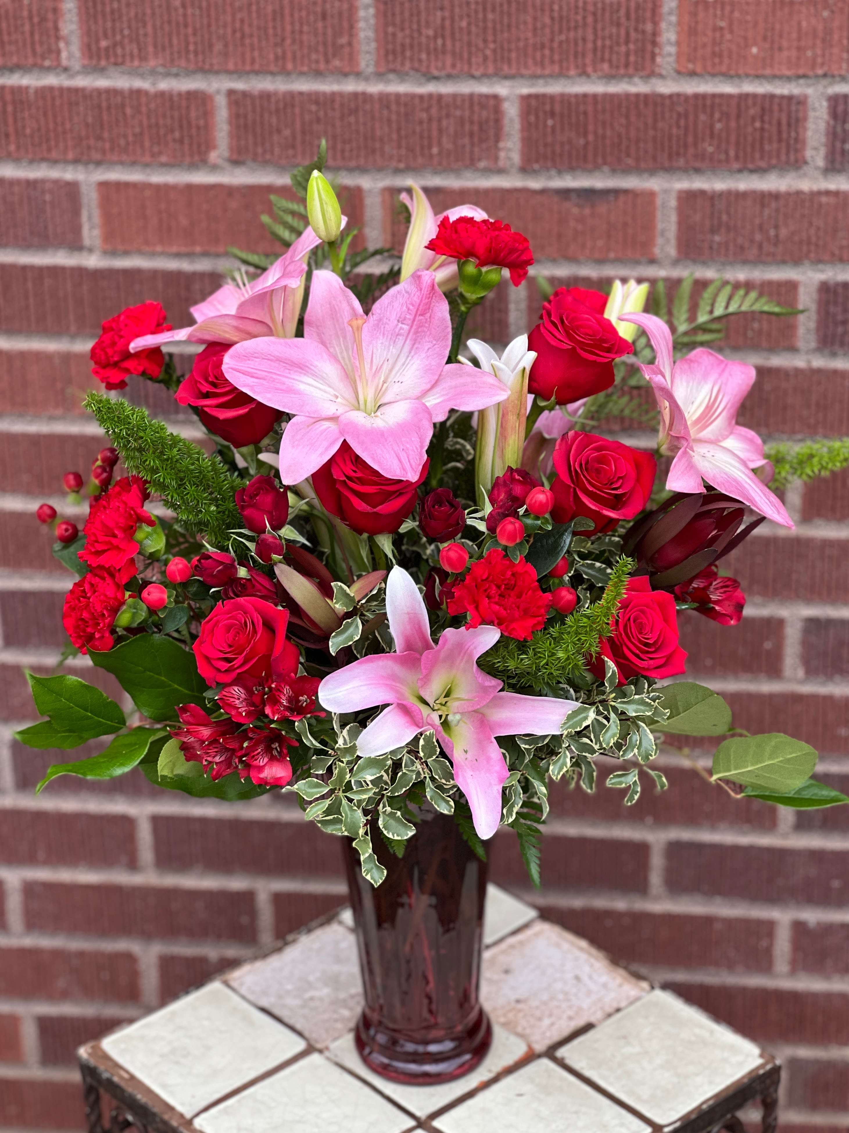 Pink lilies and red roses in a glass vase