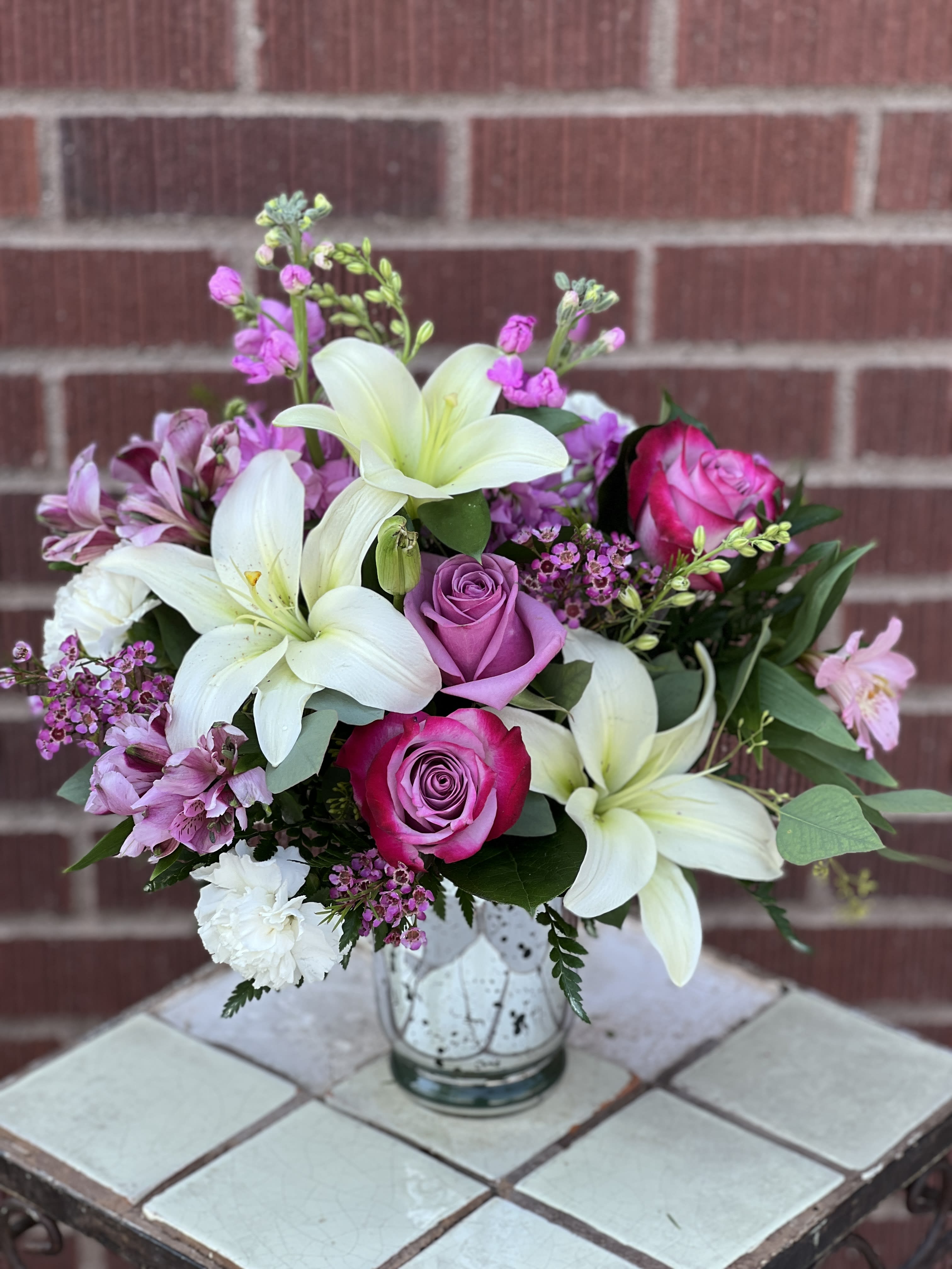 Bouquet of white lilies and pink roses in a glass vase