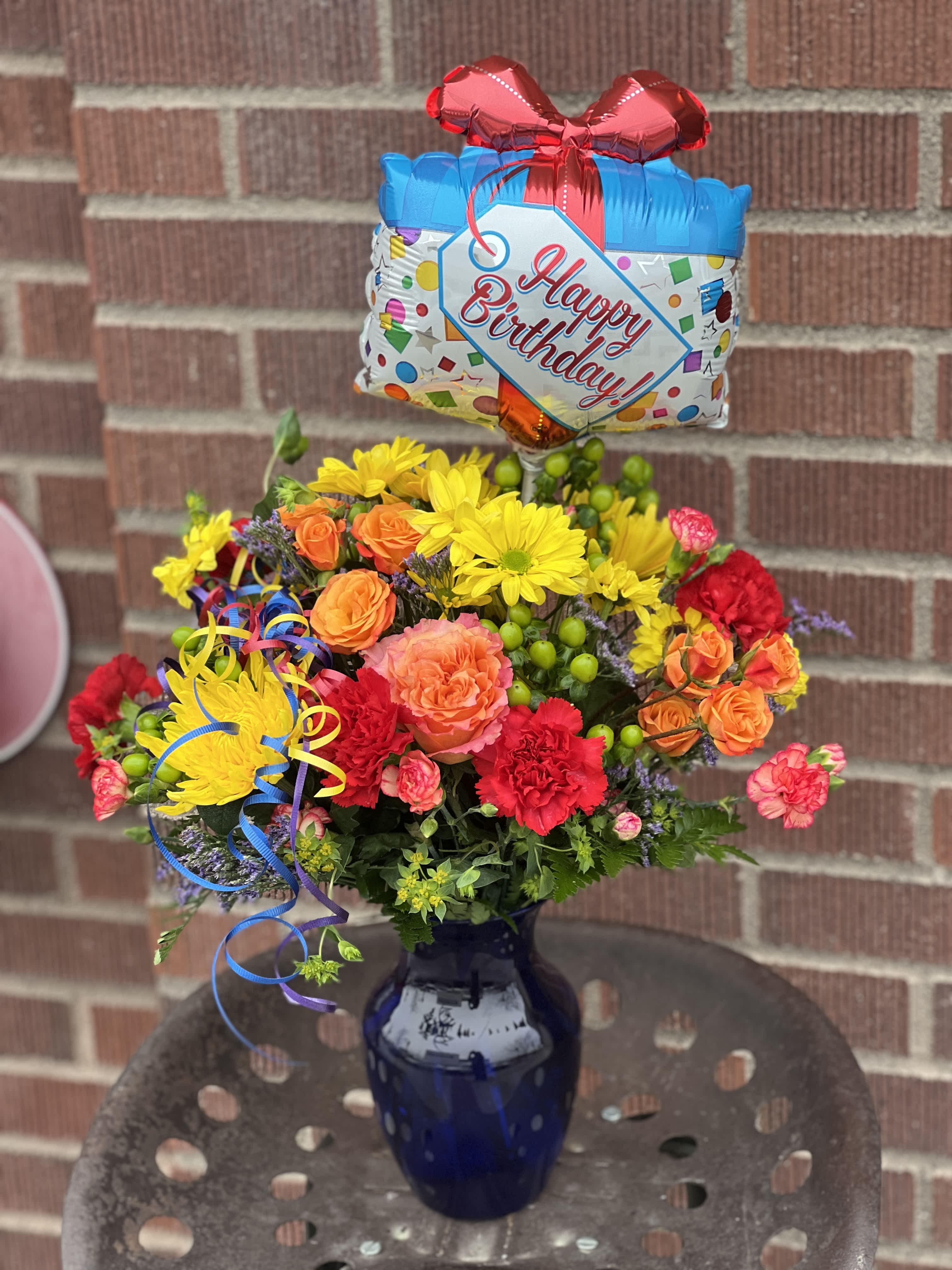 Birthday bouquet in a blue vase with a balloon topper