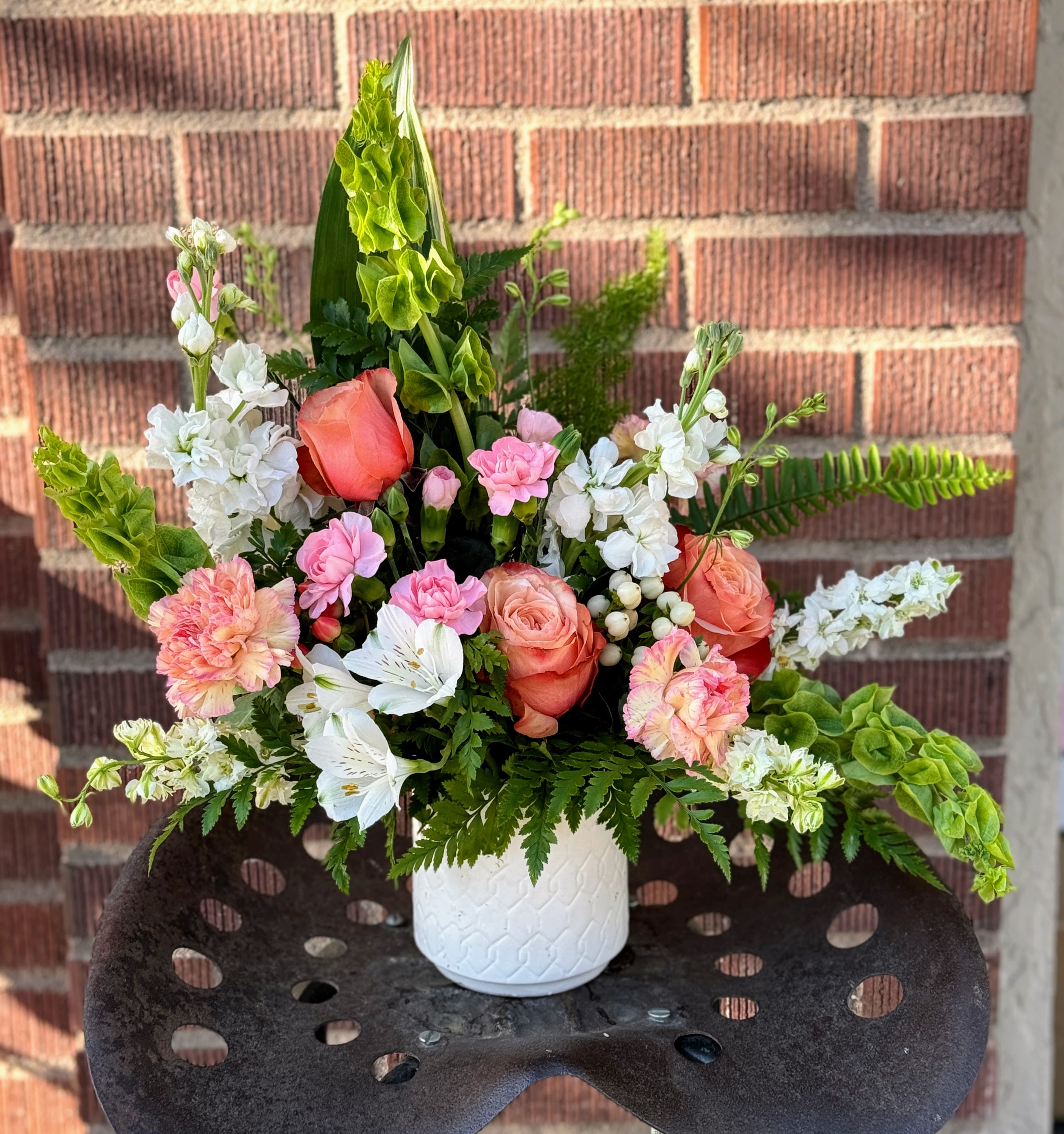 Pink and white floral arrangement in a white vase