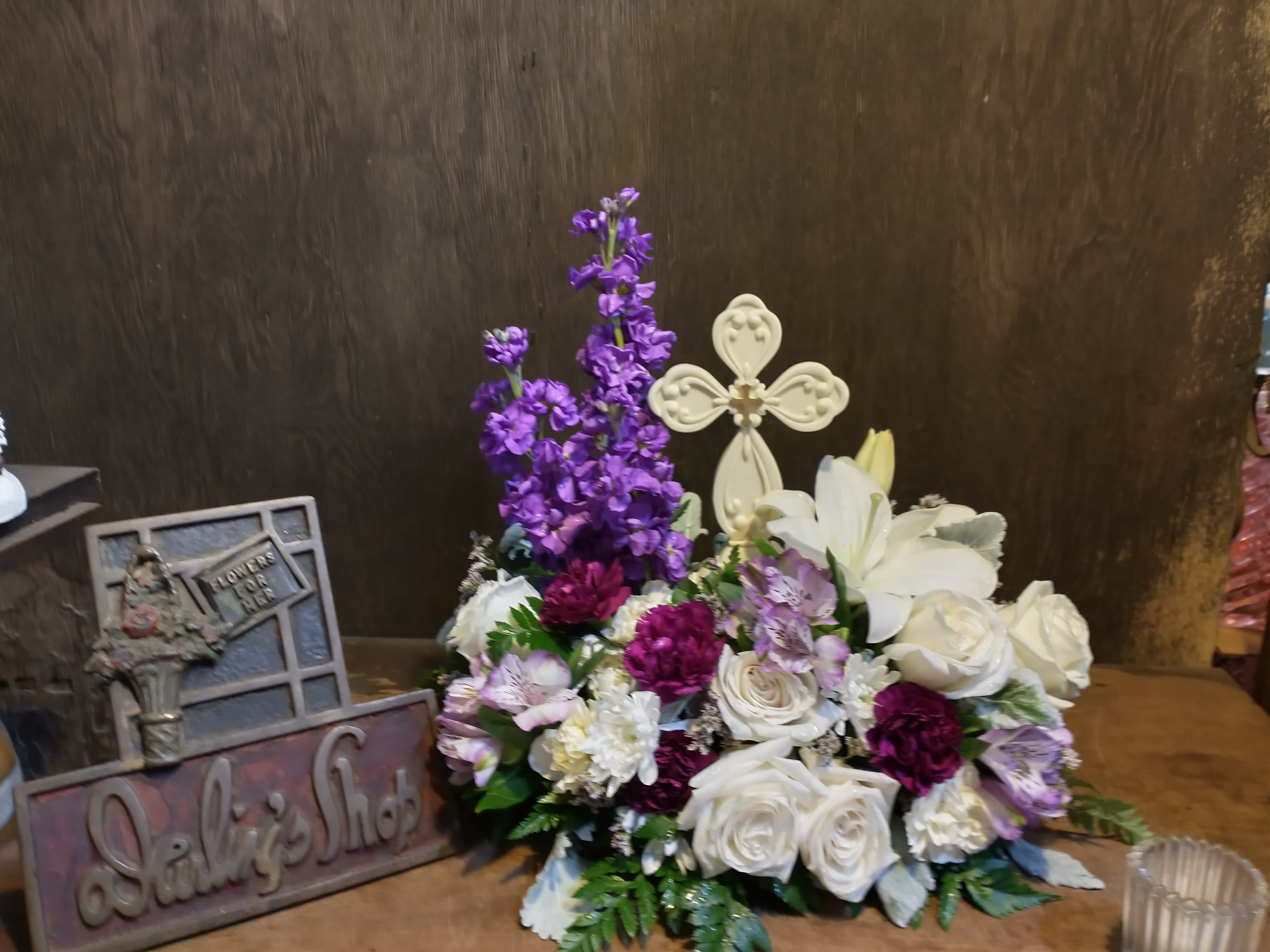 White roses and lilies with purple flowers in a low arrangement
