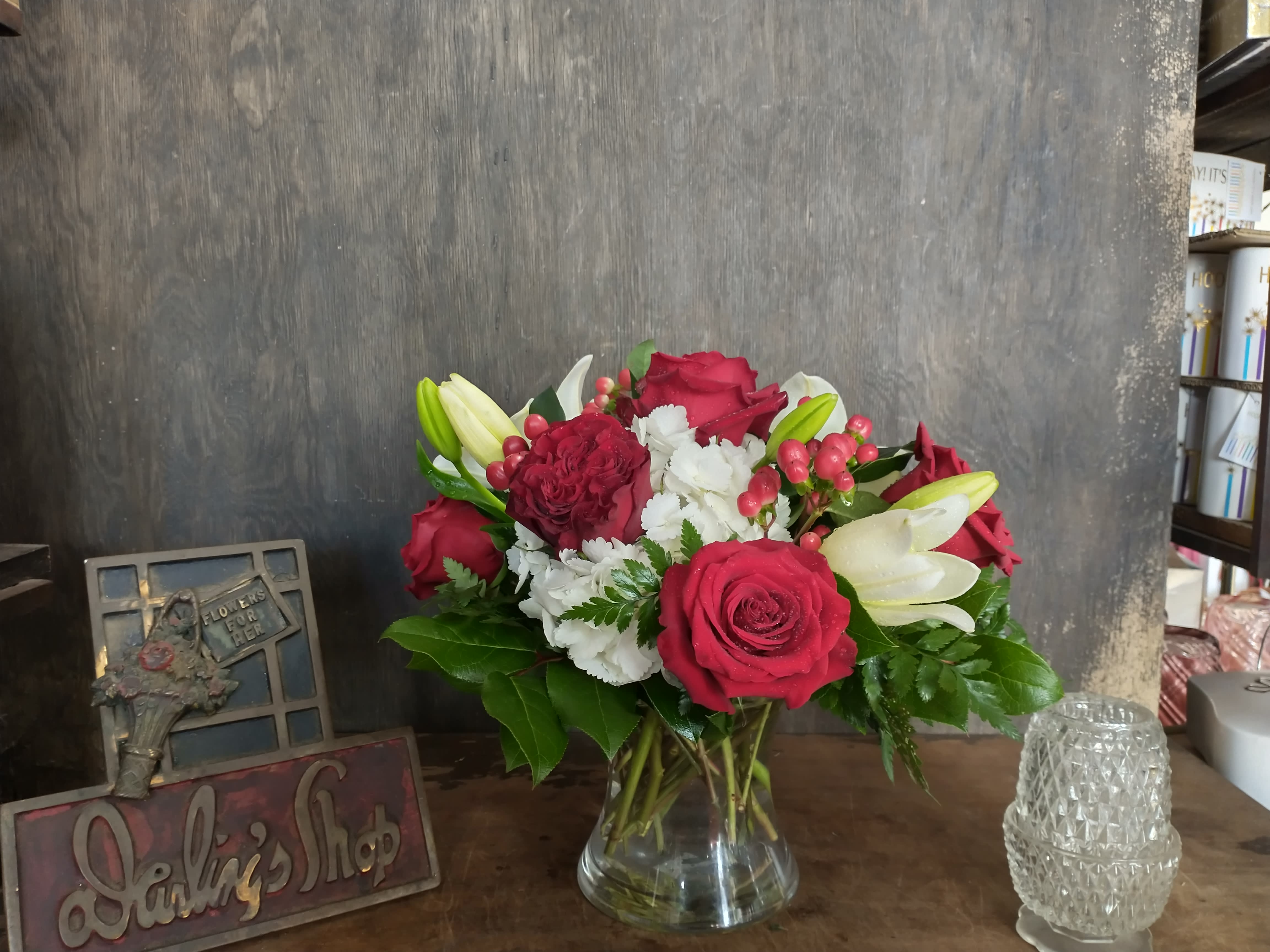 Bouquet of red roses, white lilies, and white carnations in a glass vase