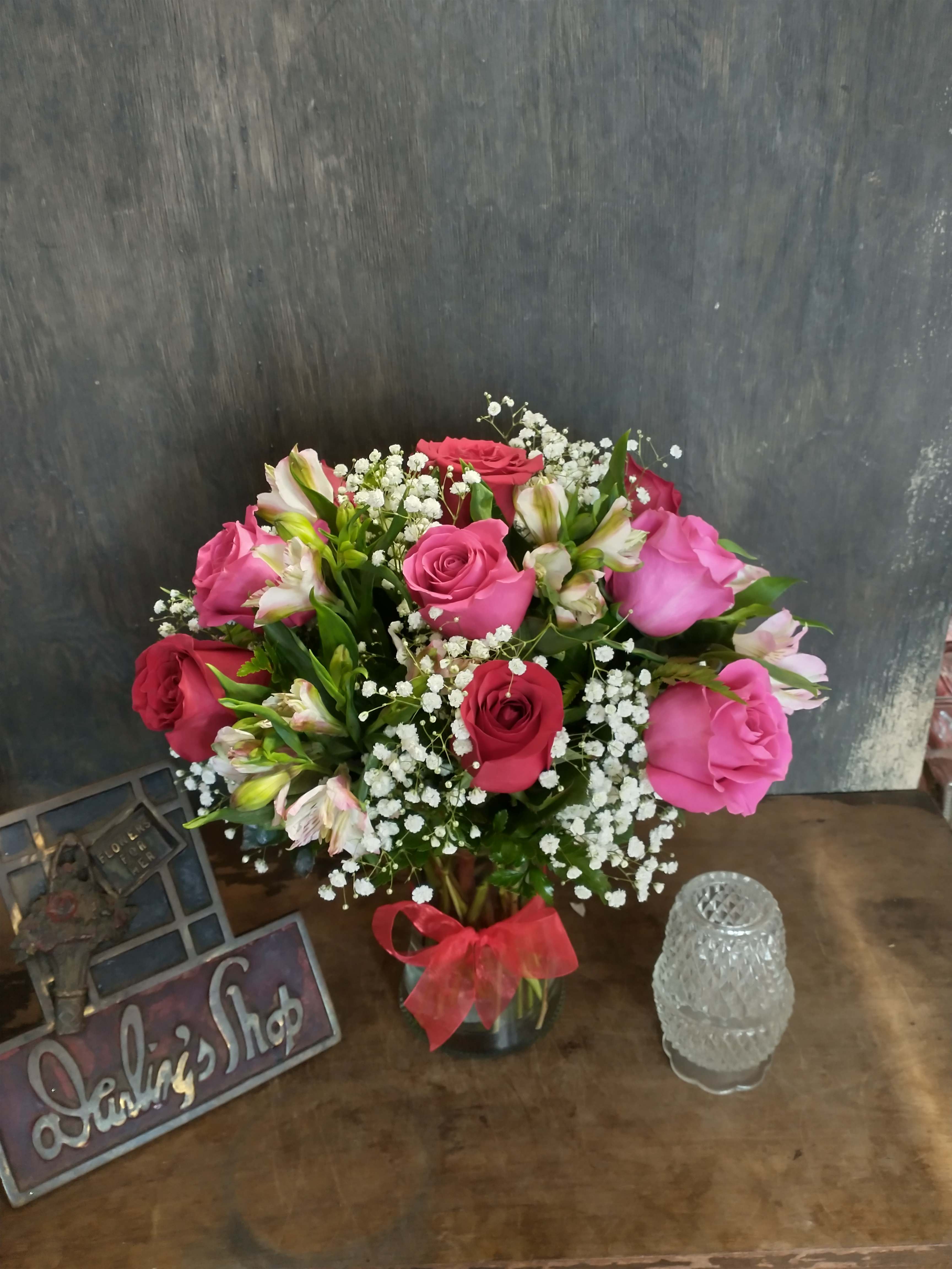 Pink and red roses with white baby's breath in a glass vase