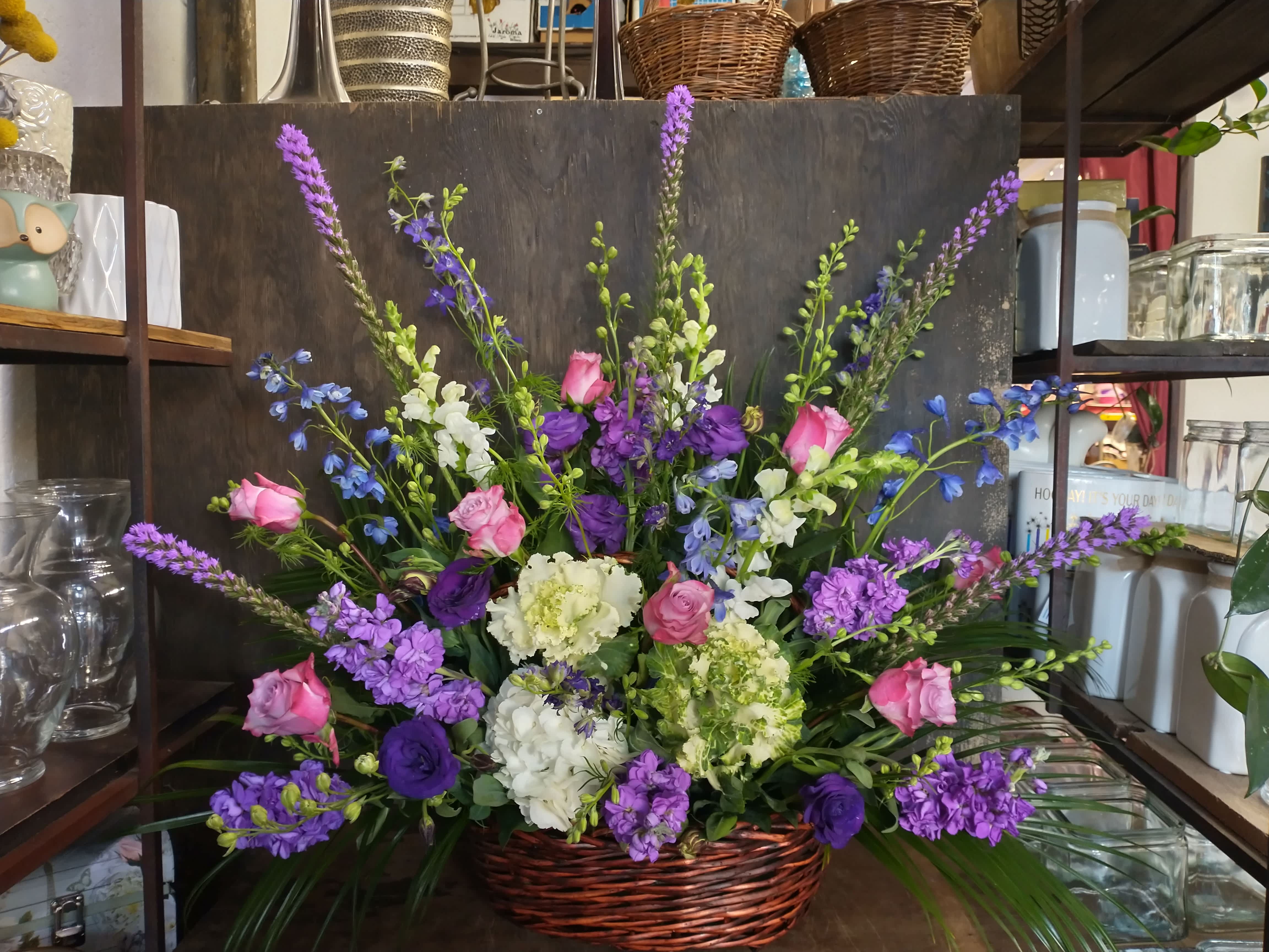 Basket arrangement of pink and purple flowers with white blooms