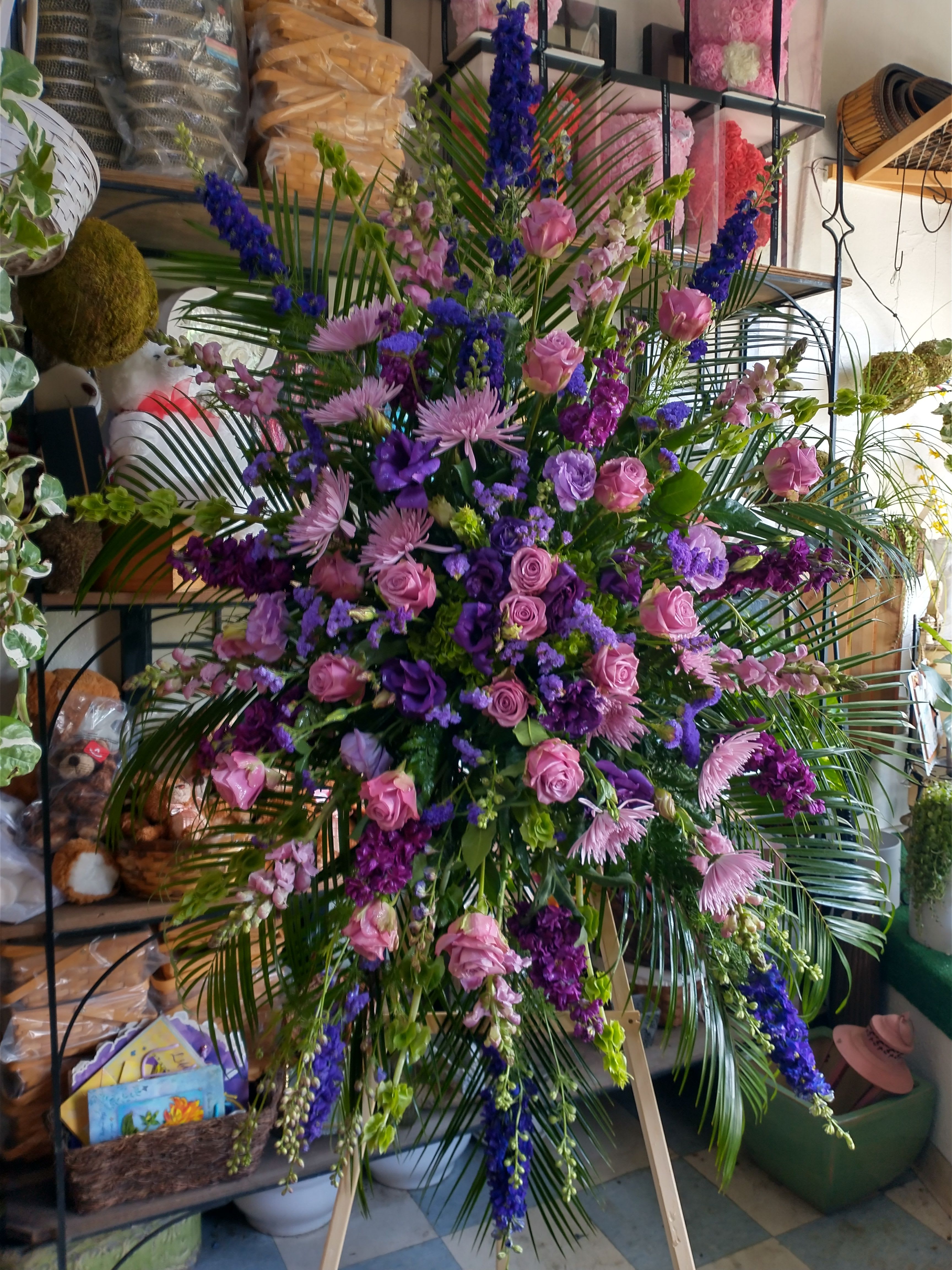 Large standing floral spray with pink and purple flowers on an easel