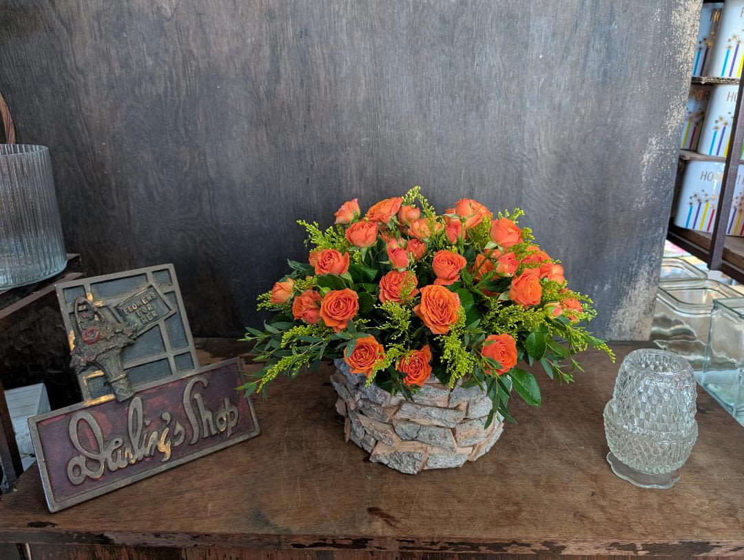 Orange rose bouquet in a stone-textured container