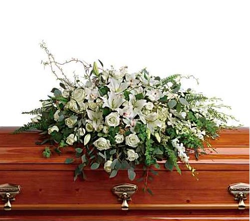White floral spray on a wooden casket