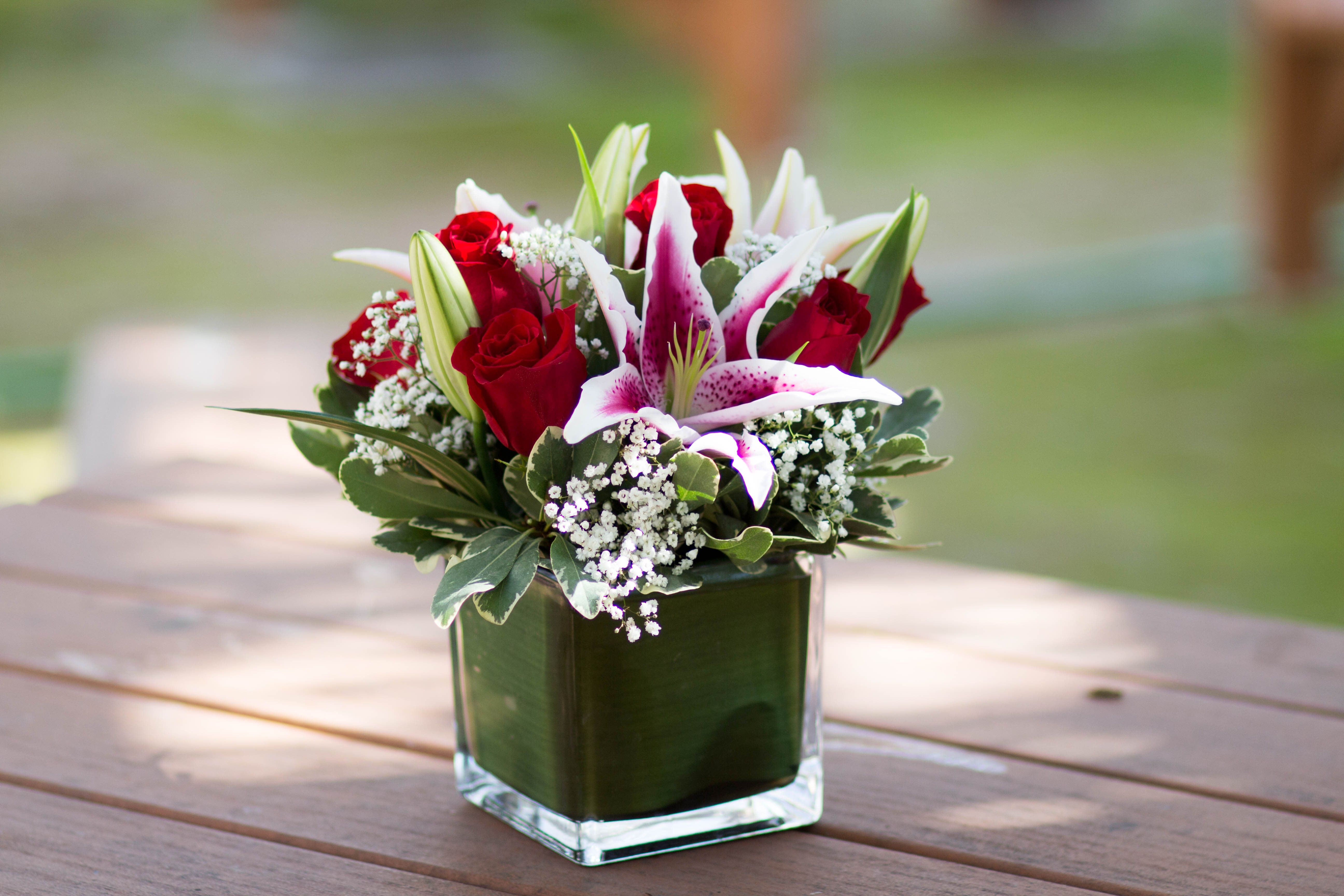 Red roses and white lilies in a square glass vase