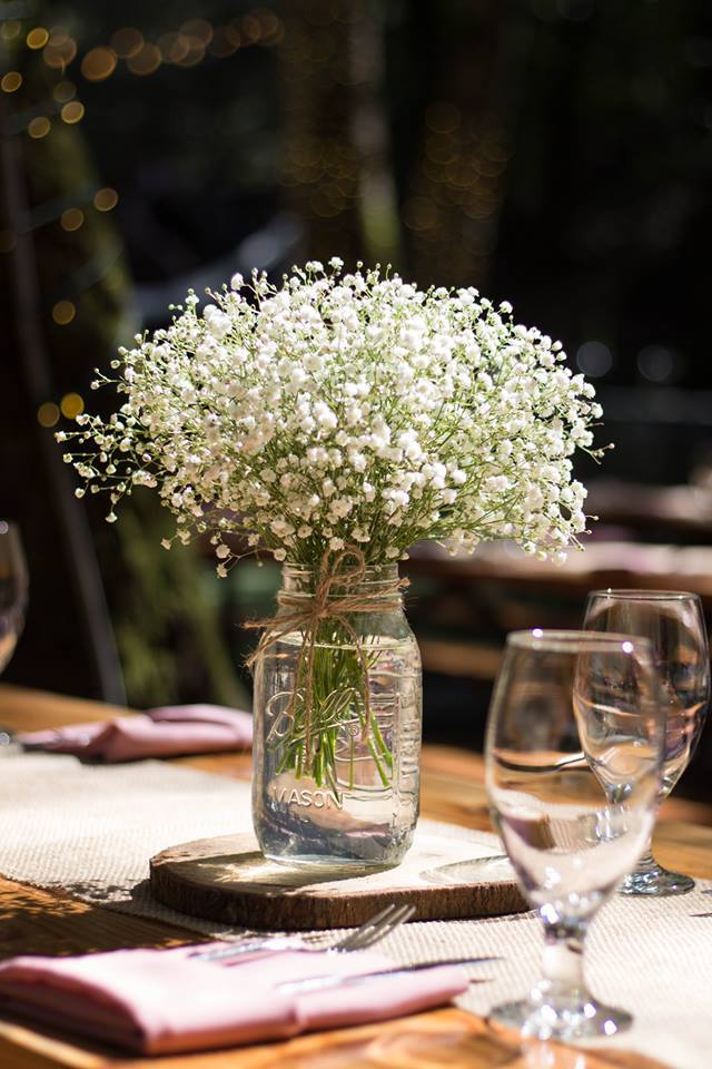 White baby's breath in a glass jar centerpiece on a table