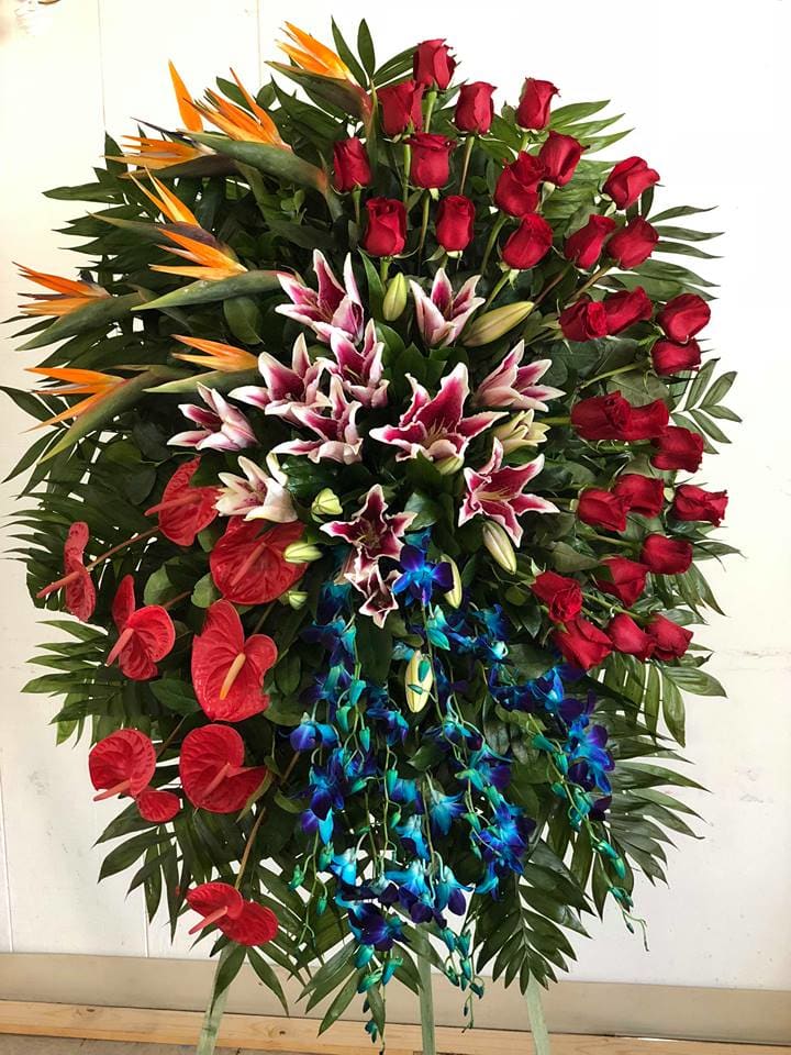 Large standing floral spray with red roses, lilies, and orchids