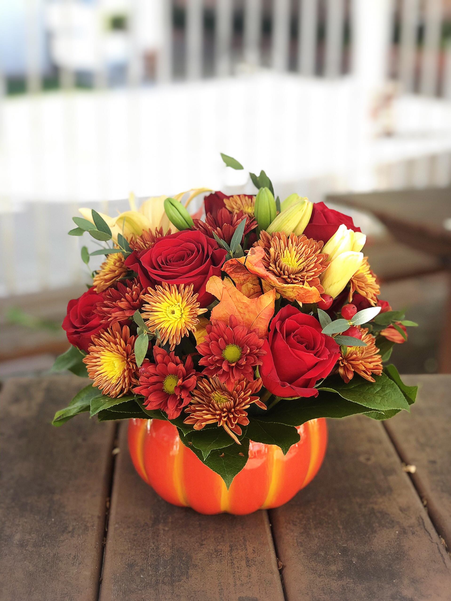 Autumn Pumpkin - -Bi-color daisies  -6 red roses -2 orange lilies -Autumn leaves -Ceramic pumpkin container