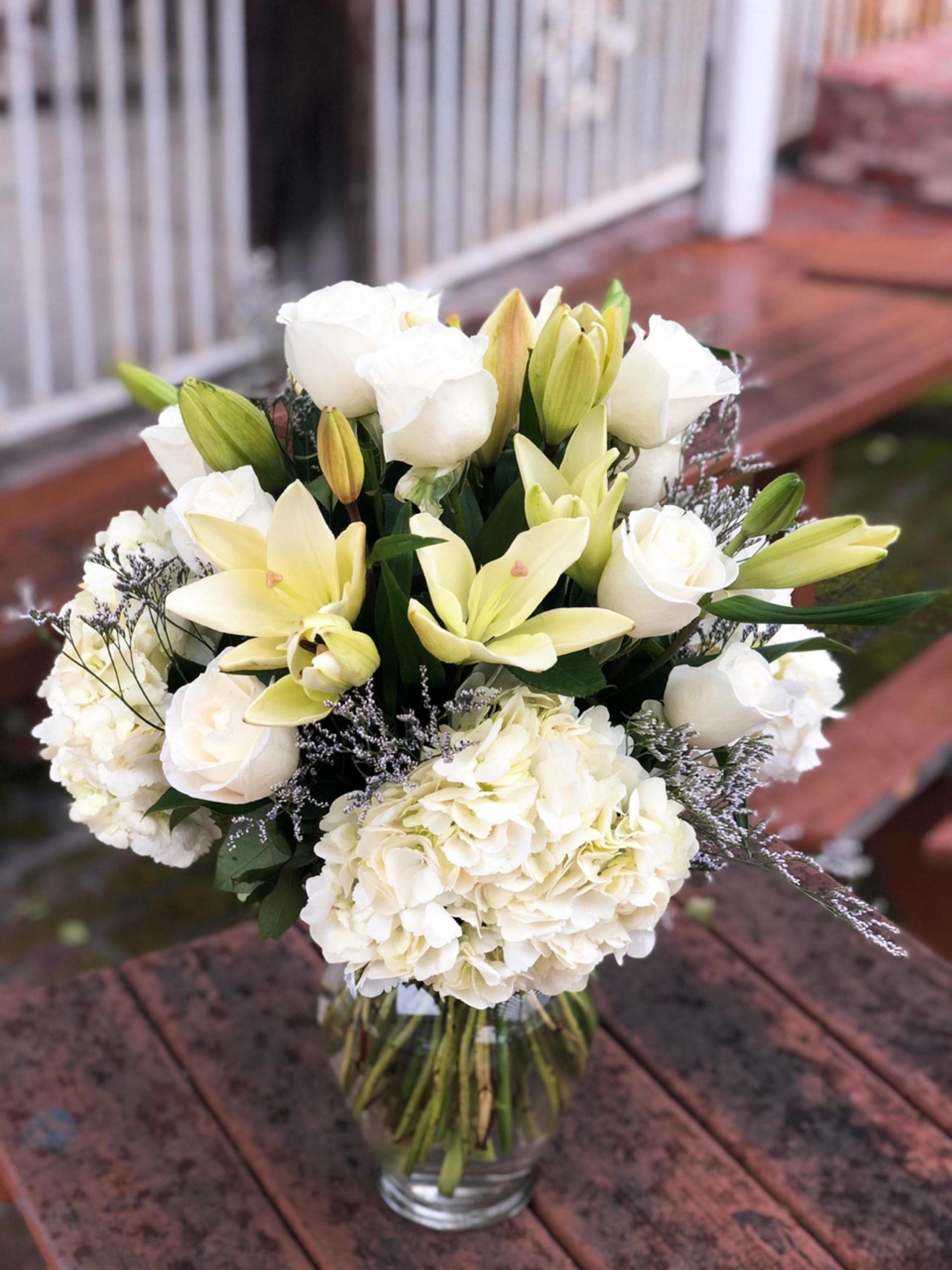 White roses and lilies arranged in a glass vase