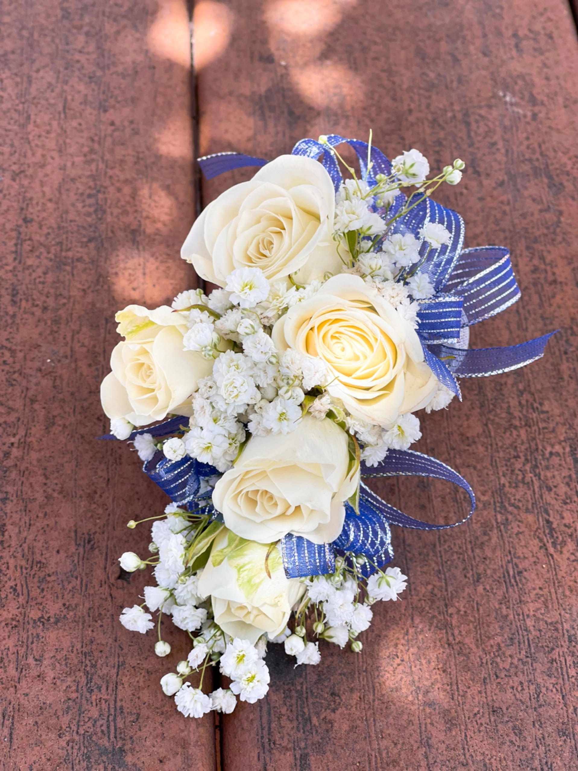 White rose corsage with baby's breath and blue ribbon