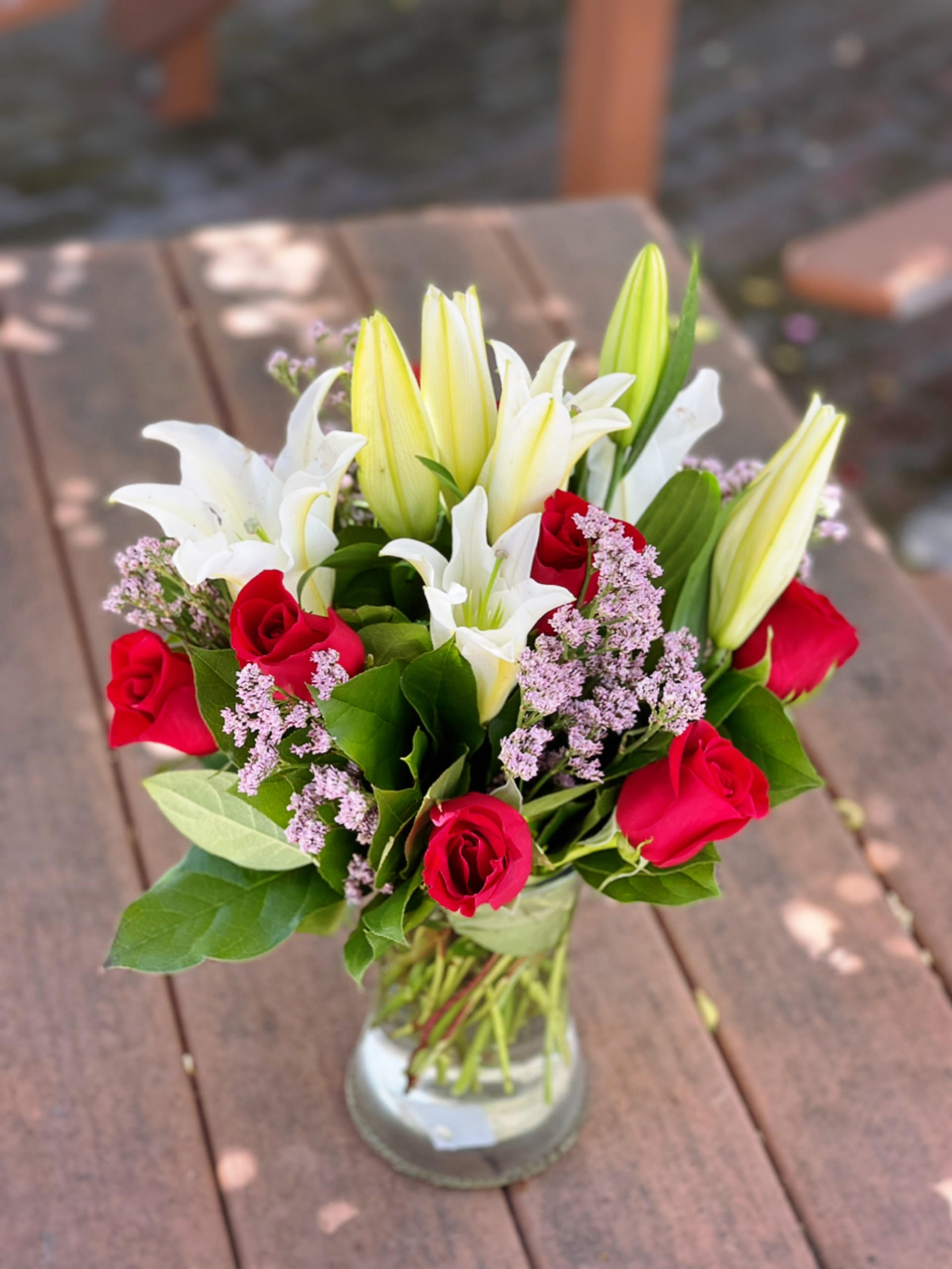 Bouquet of red roses and white lilies in a glass vase