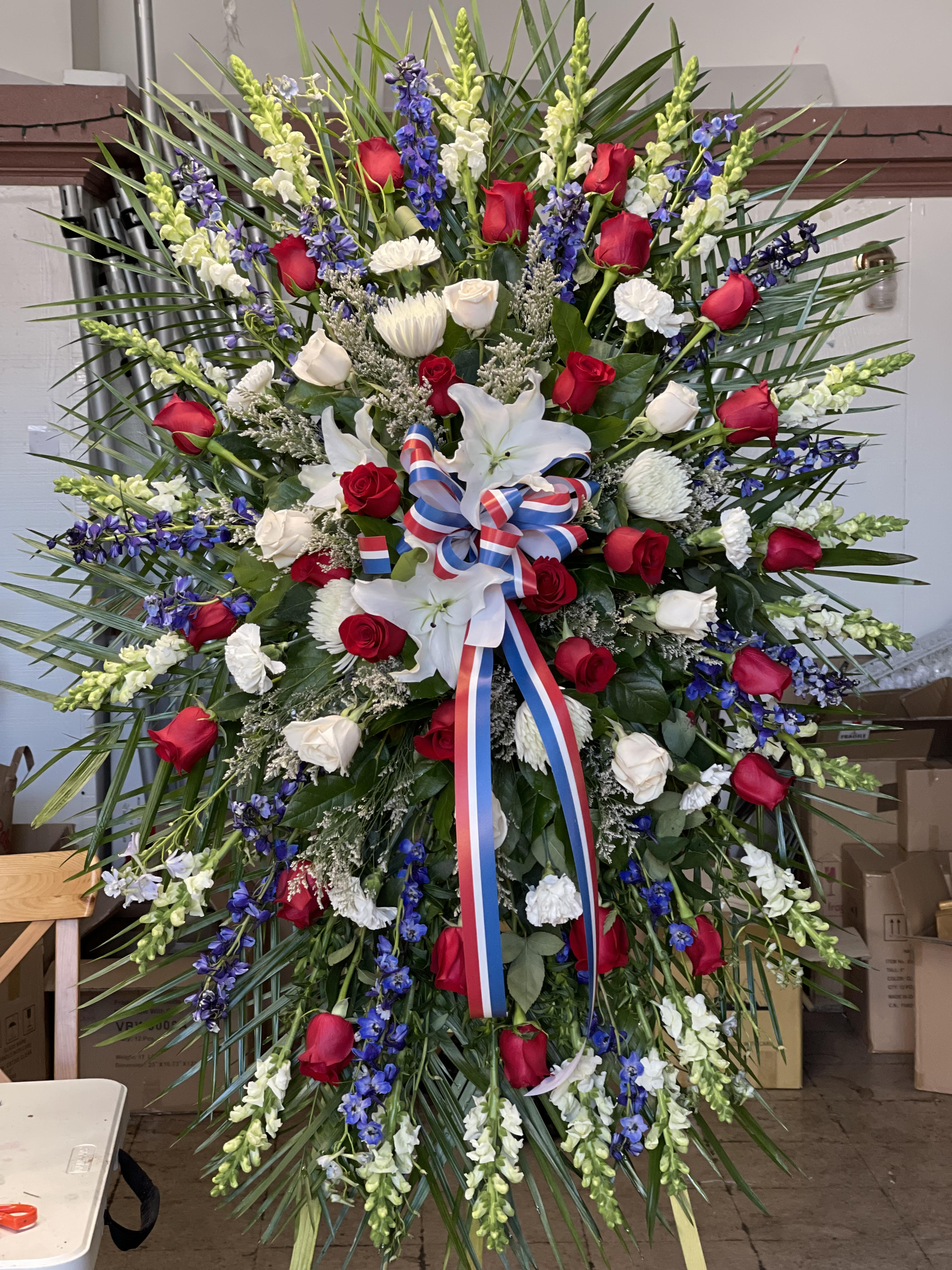 Large standing floral spray with red and white roses and white lilies
