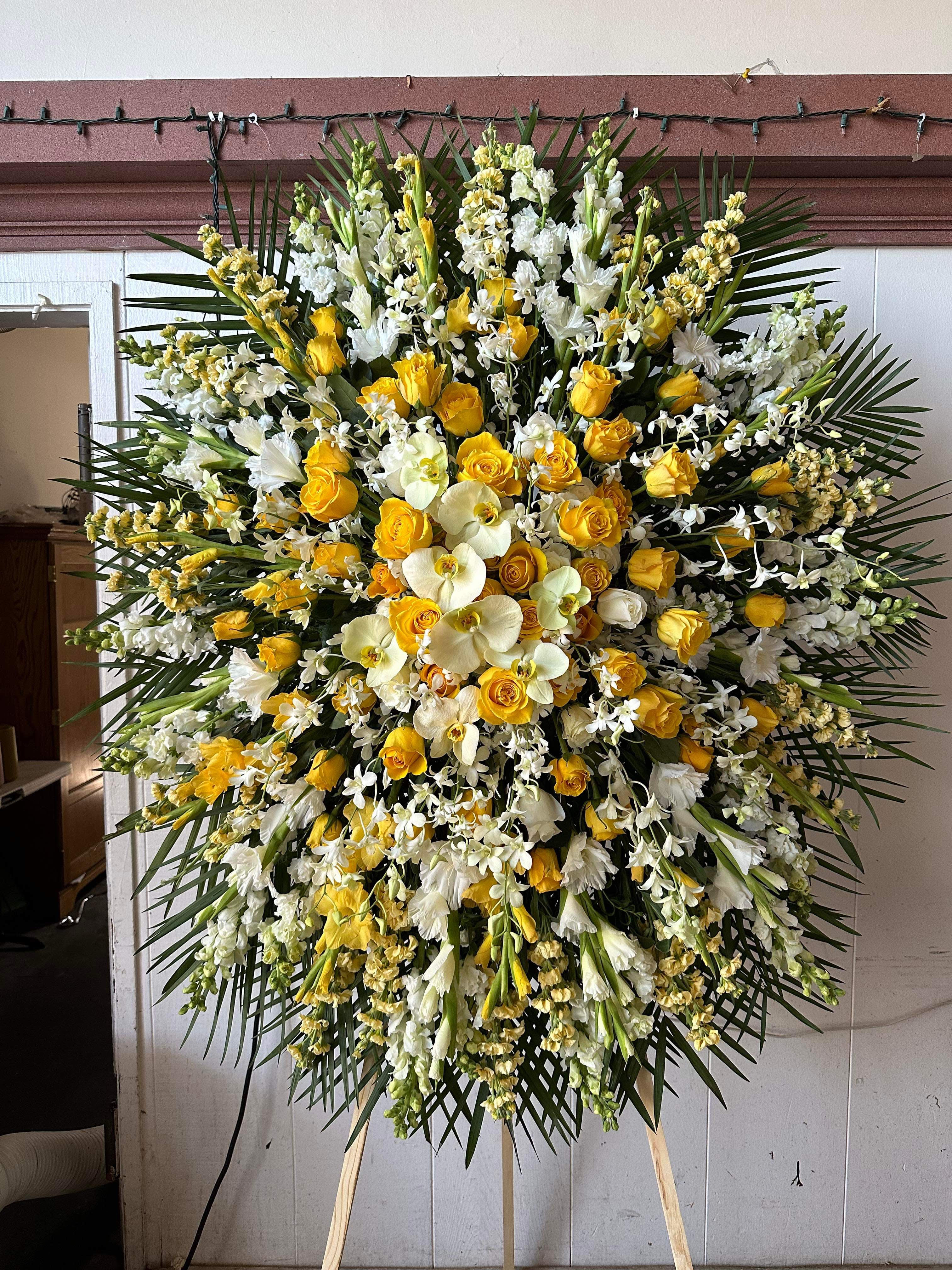 Large standing floral spray with yellow roses and white orchids