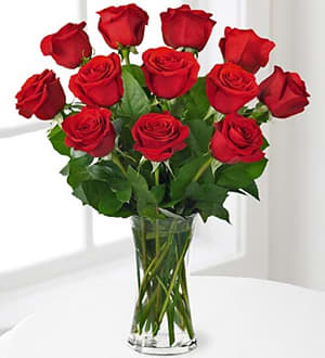 A bouquet of red roses in a clear glass vase