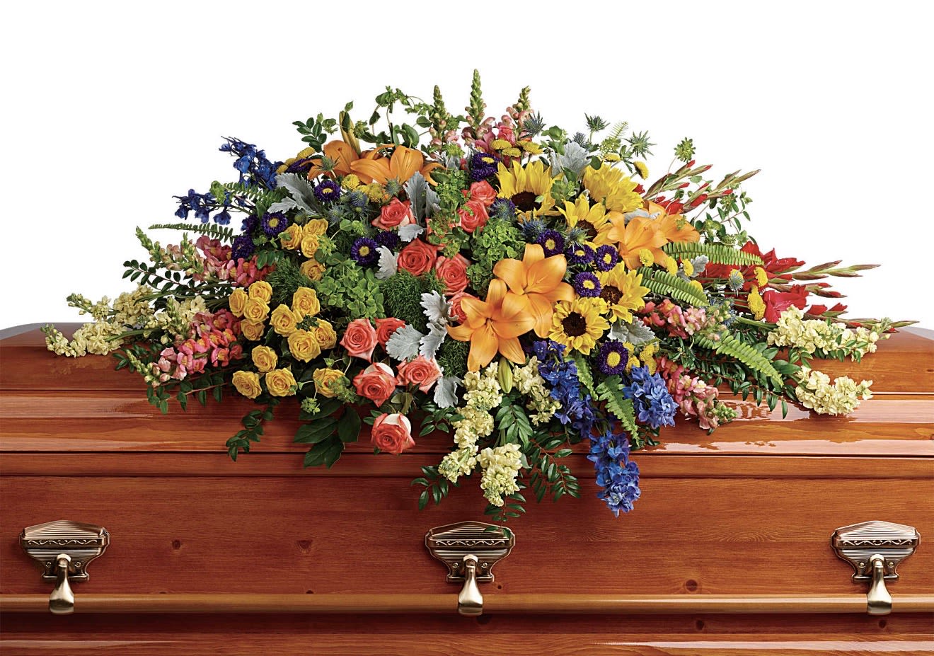 Colorful Reflection Casket Spray - A wide, radiant casket spray that brings a warm, celebratory light to a funeral or memorial service: this mixed-color flower arrangement for a casket spreads a dense, layered display across a polished wooden casket, offering a respectful yet uplifting tribute. The design is meant for memorial services and will make the person you're honoring feel remembered with joyful color rather than quiet somberness.  Sunflowers, orange lilies, pink and coral roses, daisies, snapdragons and chrysanthemums are arranged in a broad, cascading composition with blue accents and small purple and white filler blooms for depth and texture. The palette of yellow, orange and pink creates strong visual contrast while the mix of large focal blooms and smaller flowers gives the spray an abundant, tactile presence suited to a formal service setting. The piece is full and wide to cover the casket top and has a layered, flowing silhouette rather than a handheld shape.  Perfect for celebrating a life with warmth and color, this casket spray is intended for display at funerals or memorials where you want the floral tribute to read both respectful and uplifting. Because it's designed to sit across a wooden casket, sizing and placement are tailored for a service setting-please let us know the casket dimensions or service details when ordering so we can ensure the arrangement fits the display appropriately.