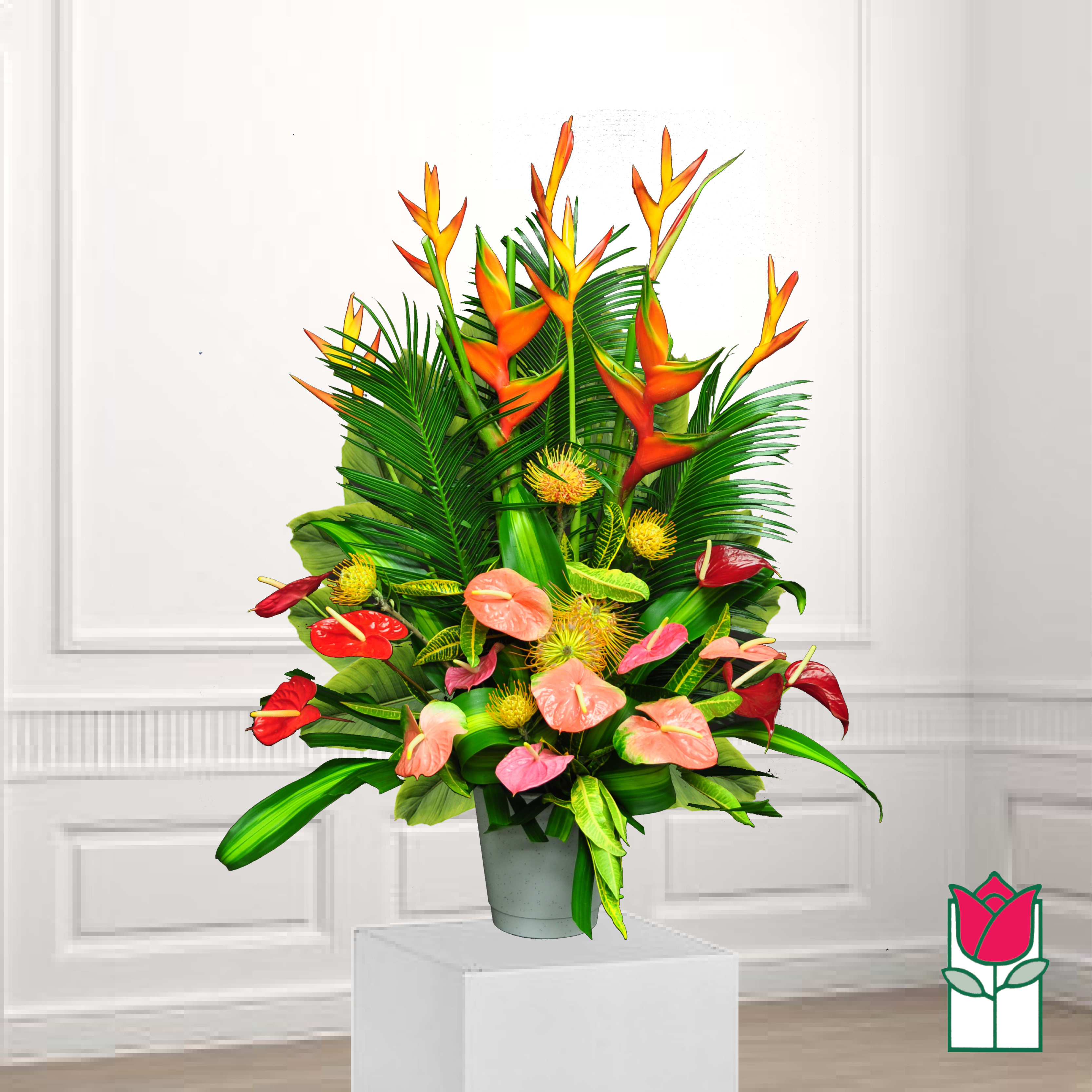 Tropical arrangement with orange heliconia and pink anthuriums in a gray pot