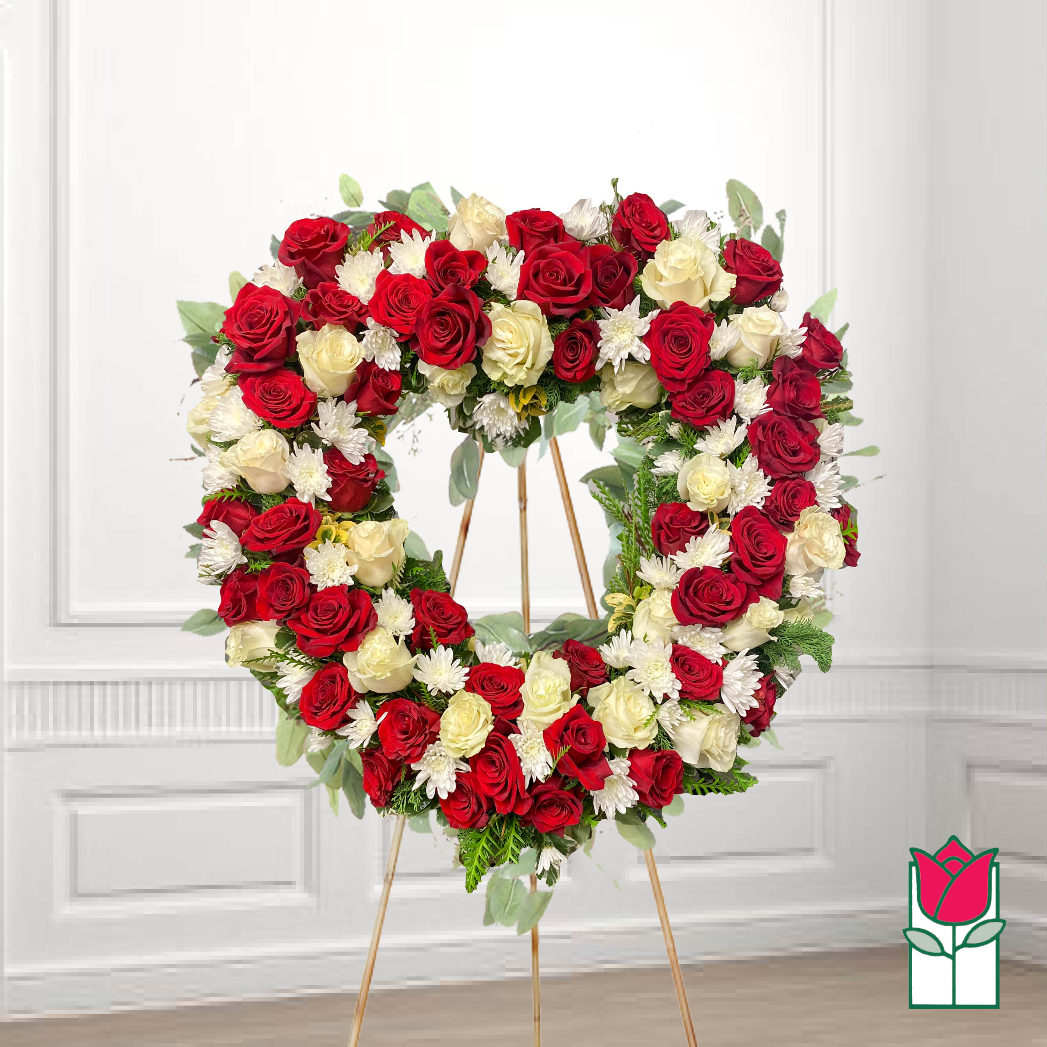 Heart-shaped wreath of red and white roses on a stand