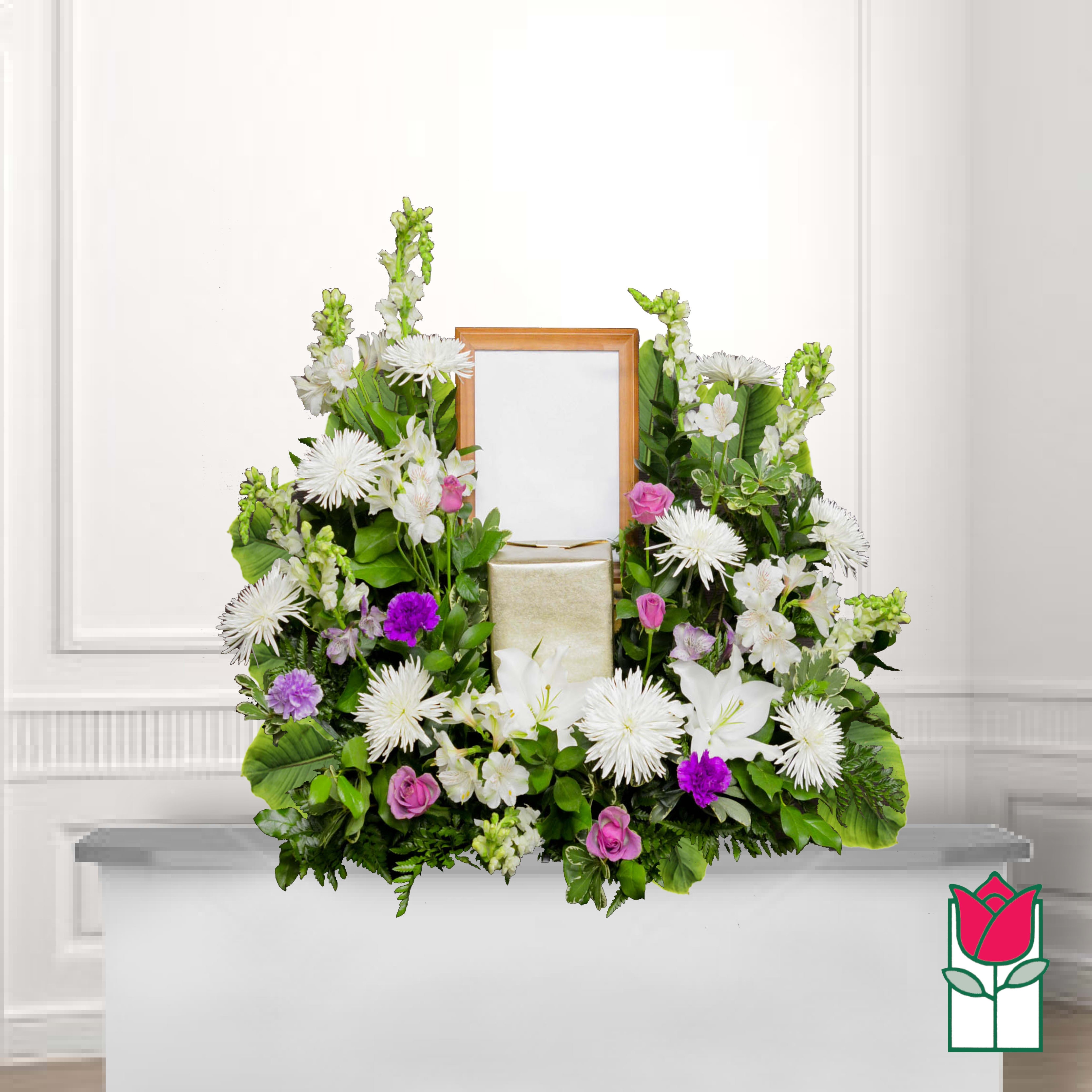 White and pink floral arrangement framing a wooden picture frame and gift box