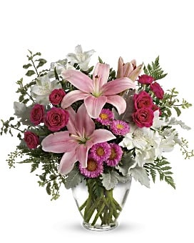 Pink lilies and roses in a clear glass vase