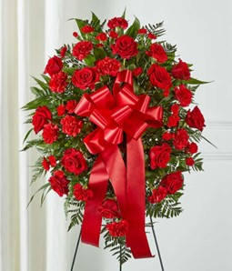 Standing spray of red roses and carnations with a large red ribbon
