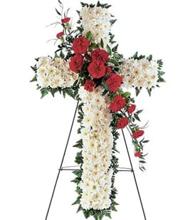 Standing floral cross with white and red flowers on an easel