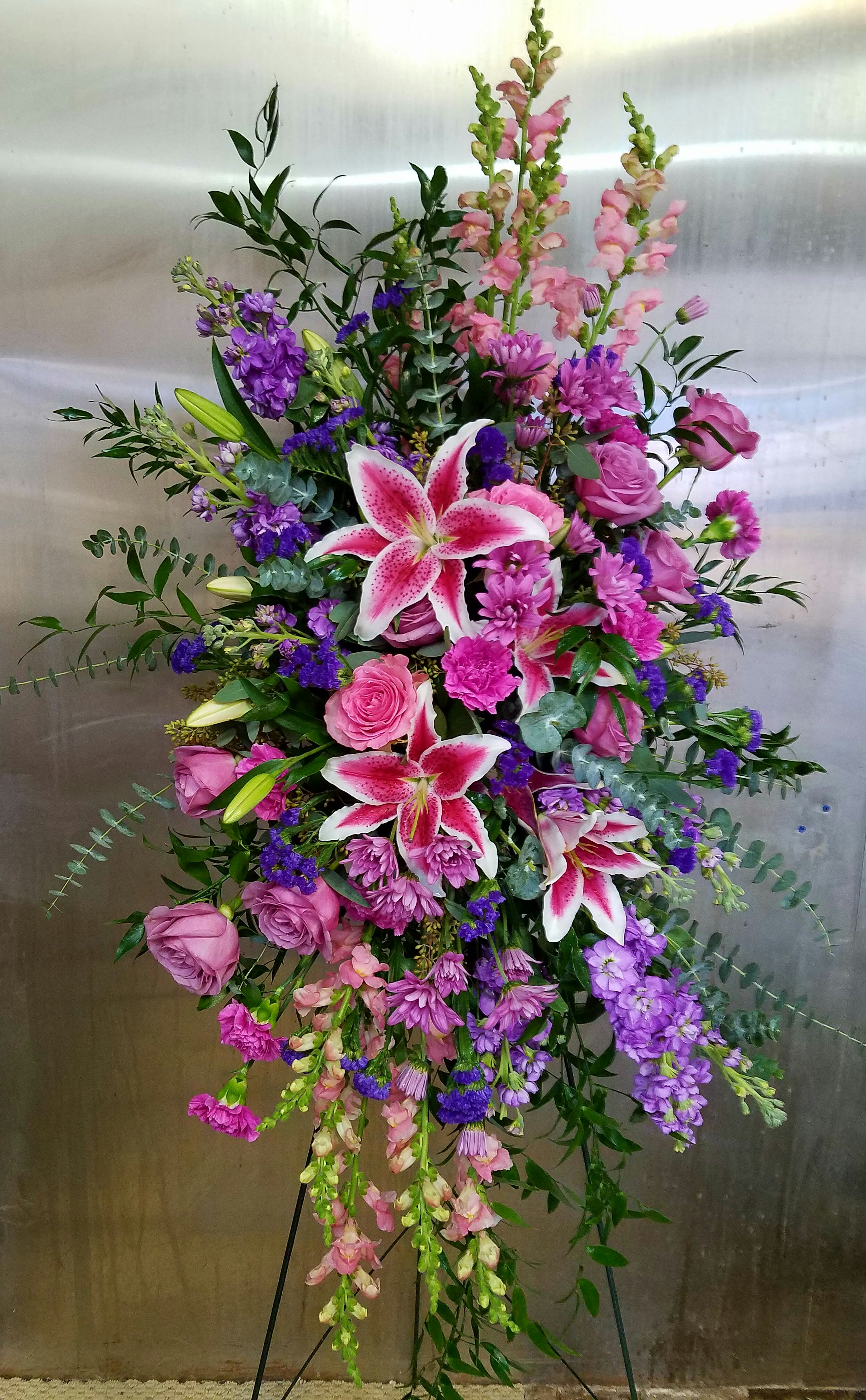 Eckert Florist's Pink and Lavender Standing Spray - This standing spray's focal point is beautiful stargazer lilies surrounded by our most elegant pink and lavender blossoms.