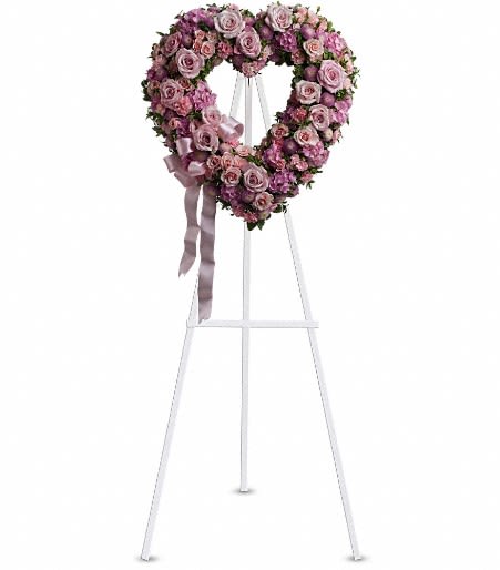 Heart-shaped pink and lavender rose wreath on a white standing easel