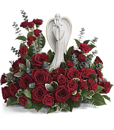 Red rose arrangement with a white angel figurine in the center