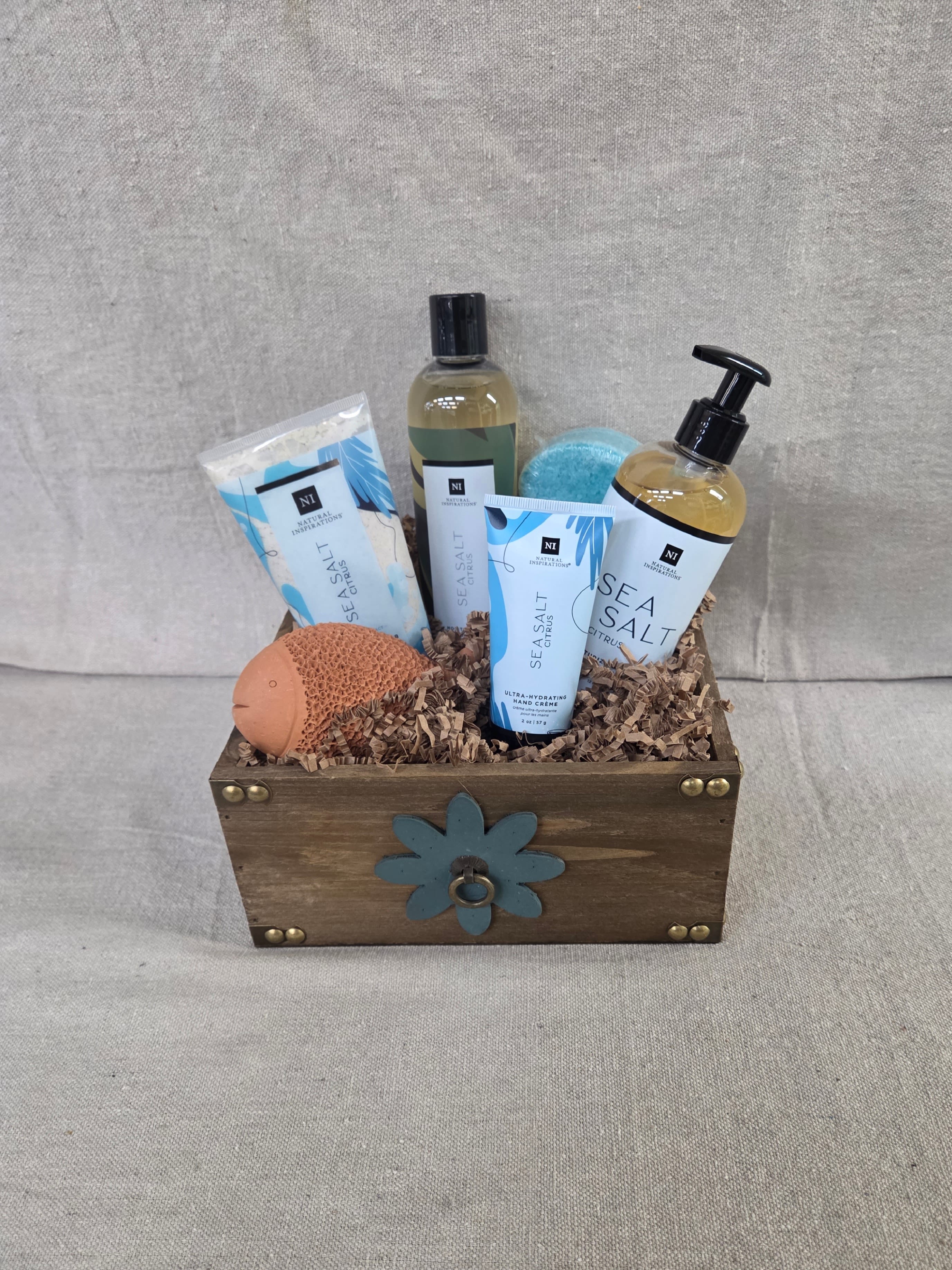 Wooden gift crate with sea salt bath products, lotions, sponge, and a blue bath bomb