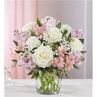 Pink and white bouquet of roses and lilies in a clear glass vase