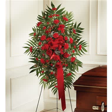 Standing red floral spray beside a casket