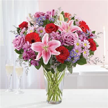Adoring Love Bouquet - For the one you adore above all else, here’s a Valentine’s surprise designed to wow! Our spectacular arrangement is filled with a lush abundance of blooms in soft &amp; bold shades for an exciting contrast of color. Artistically hand-designed by our expert florists, it’s a gift that expresses all the ways you love her. • All-around arrangement with red and lavender roses; pink Oriental lilies; red Gerbera daisies; purple Peruvian lilies (alstroemeria), accented with assorted greenery • To ensure lasting beauty, Oriental lilies and Peruvian lilies may arrive in bud form, and will fully bloom over the next few days • Our florists select the freshest flowers available, so colors and varieties may vary due to local availability • Artistically designed in a clear glass vase; measures 12"H • Large arrangement measures approximately 30"H x 22"L • Small arrangement measures approximately 26"H x 19"L