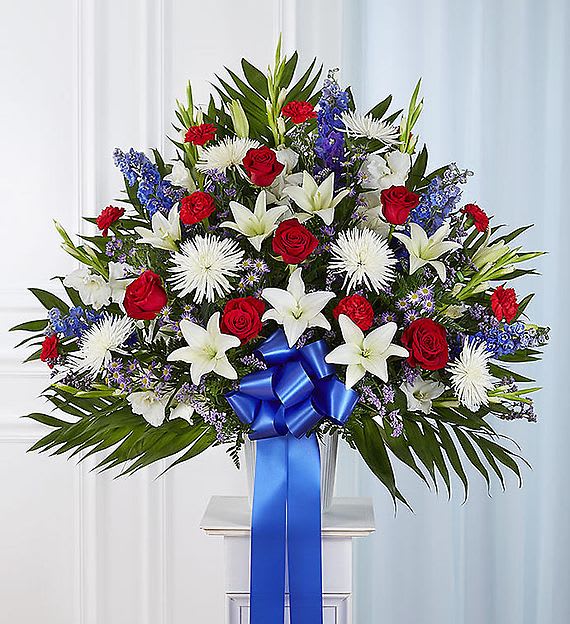 Heartfelt Sympathies Standing Basket - Red, White, and Blue - Gorgeous asiatic lilies, white chrysanthemums, red roses, red carnations, and blue delphinium create an elegant arrangement to honor the death of a loved one. 34"H x 36"W