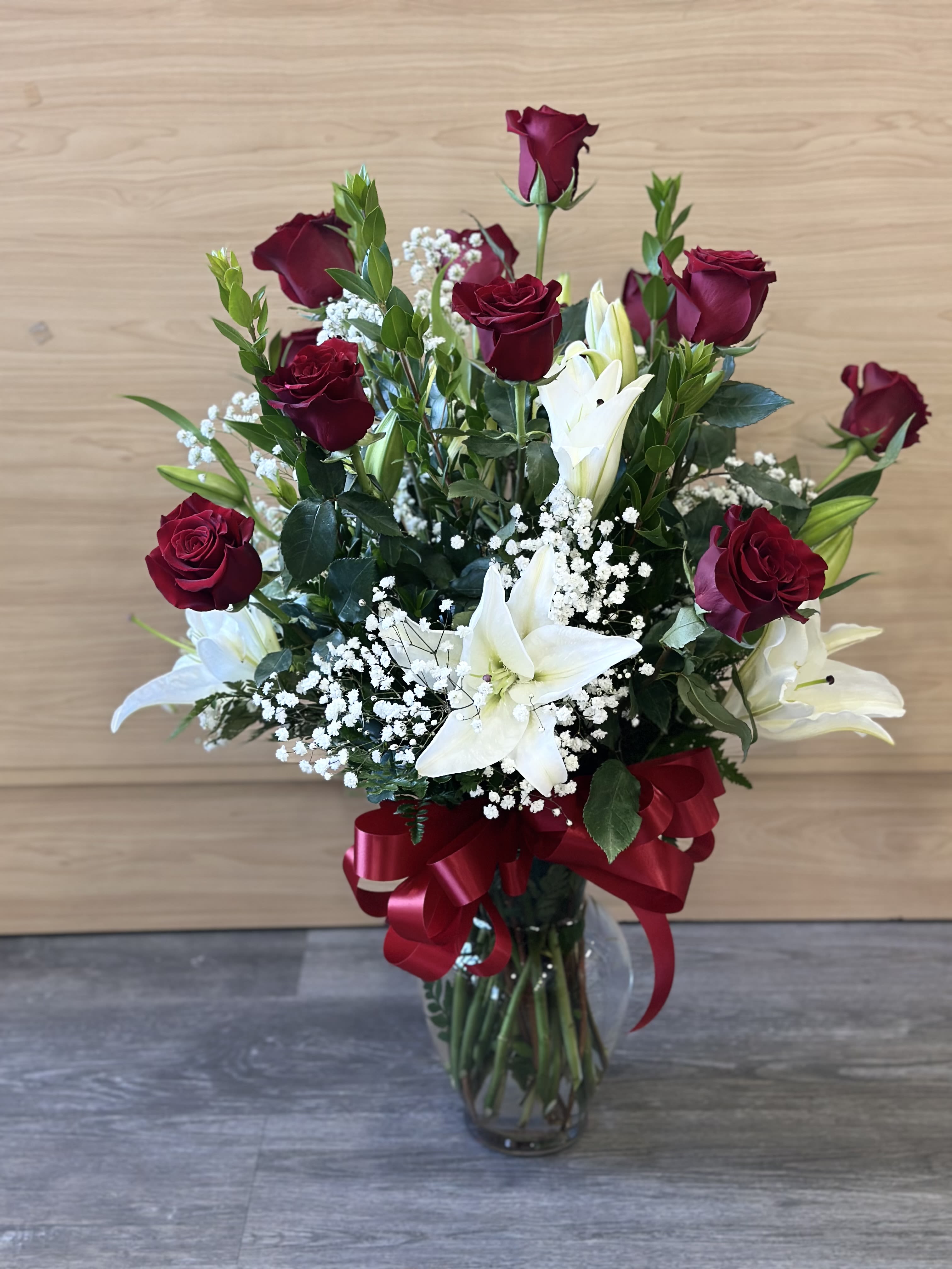 Rose and Lily arrangement - One dozen of our long stem red roses Casablanca Lilies arranged in a clear glass vase. 