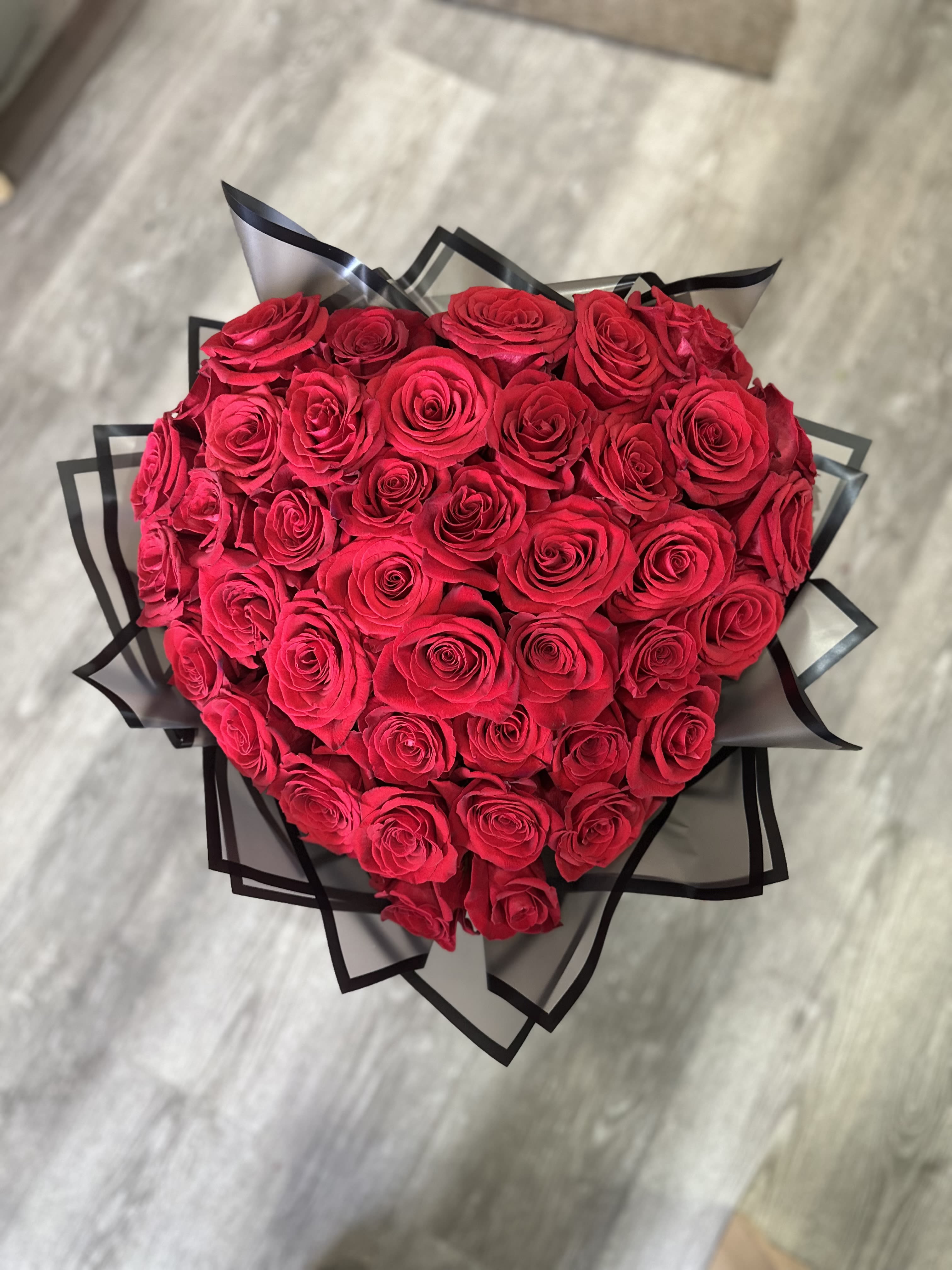 Heartfelt  Red Roses Heart Bouquet - Make a grand gesture with our Heartfelt Red Roses Heart Bouquet. Fifty lush, red roses are artfully arranged in a heart shape, perfect for expressing love and devotion.  Ideal for anniversaries, Valentine’s Day, or any special moment, this stunning bouquet is a symbol of your deepest feelings. Delivered fresh and beautifully presented, it’s the perfect way to show someone how much they mean to you.