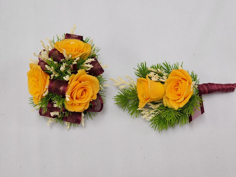 Yellow rose boutonnieres with burgundy ribbon and greenery