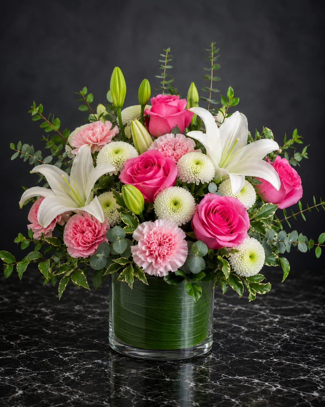 Pink roses and white lilies arranged in a glass vase