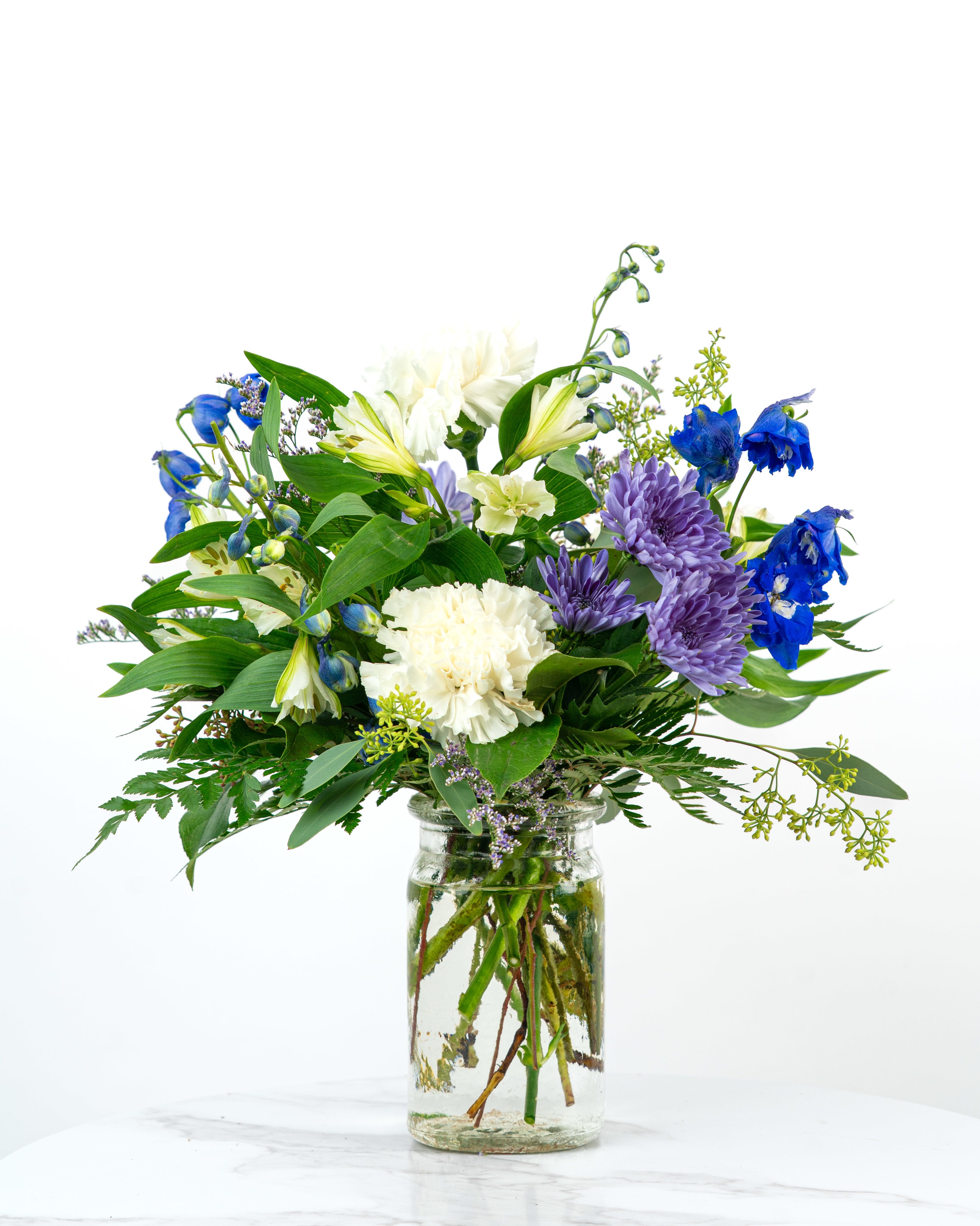 Our Birthday Collection: Coolest Blooming Birthday Wishes - Our Blooming Birthday Wishes Collection celebrates birthdays with bright blooms in cheerful hues. The Coolest Blooming Birthday Wishes arrangement is bursting with cool-toned color and fresh-picked charm to make someone's special day unforgettable. Send birthday wishes with this one of a kind arrangement styled just for your order. Because we always use the freshest blooms, your final arrangement may not look exactly as pictured due to seasonal availability.