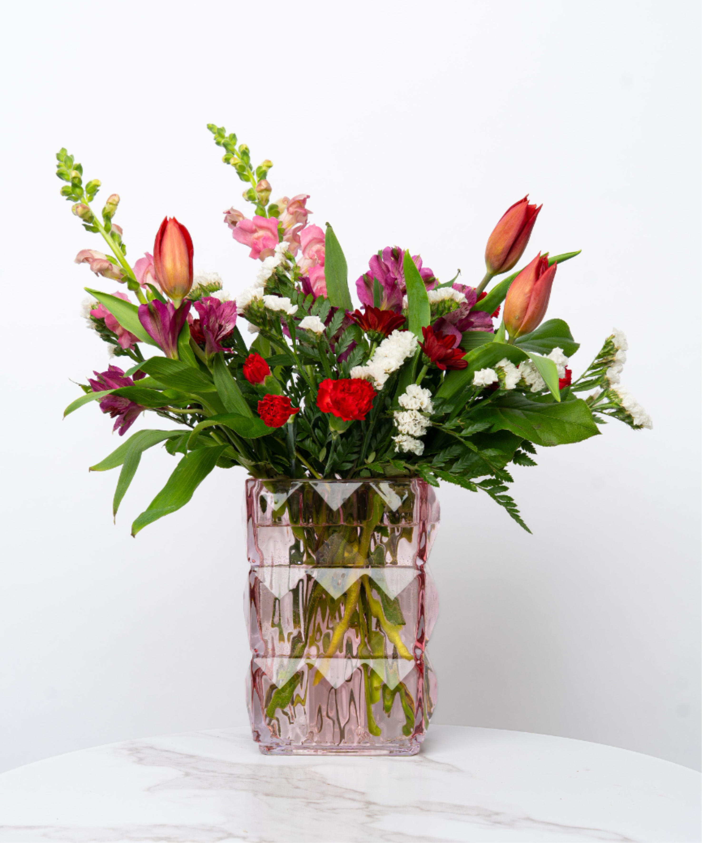 Our Valentine's Day Collection: The Ophelia - Looking for a poetic and romantic floral arrangement? The Ophelia is a tulip floral mix arranged in a glamorous, artistic vase. The airy florals combine the ethereal beauty of Ophelia (Shakespeare’s Hamlet), making this a show-stopper for the love of your life.  At Schultz Floral, we believe in two things: high quality blooms and real photography of our products. Each arrangement is one of a kind and styled just for your order in our Valparaiso Shop, so your final arrangement may not look exactly as pictured due to daily availability. 