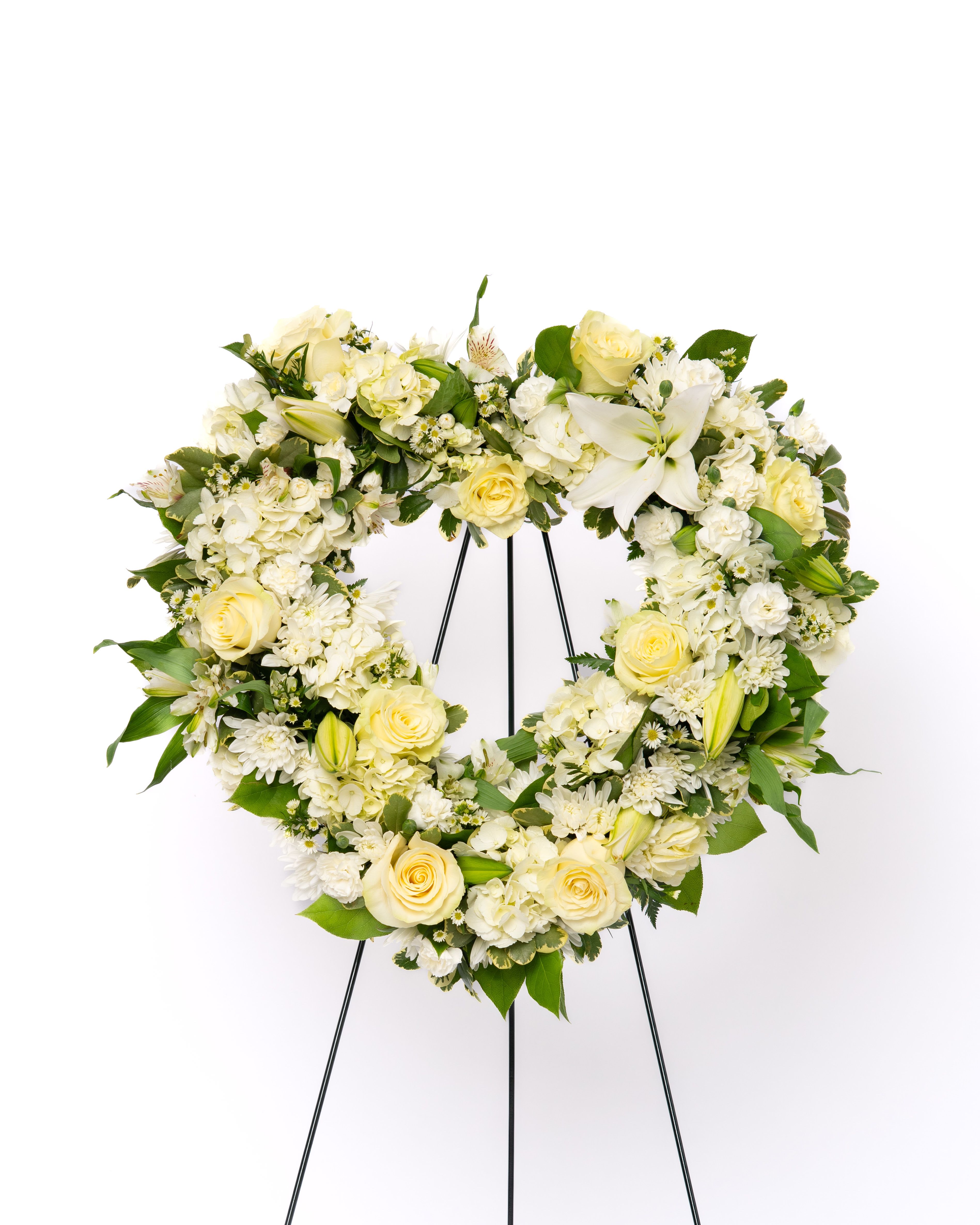 Our Gentle Thoughts Collection: 18" Heart Wreath - A timeless symbol of love and remembrance, this heart-shaped wreath offers a graceful and meaningful tribute. Designed in an all-white palette, it conveys purity, peace, and heartfelt sympathy, creating a soft and elegant presence at the service. Perfect for honoring a close relationship, this design is thoughtfully arranged to express compassion and enduring love.  Each arrangement is thoughtfully designed using the freshest blooms available. Flower varieties may vary based on availability while maintaining the overall style, color palette, and value.  Approximate Dimensions of Floral Tribute: 50" tall x 22" wide  Color &amp; Customization: Need a custom color scheme? Contact us for more information. Our most popular palettes include whites, whites and greens, whites and blues, pinks and whites, pastel shades, and colorful designs.  Delivery: All sympathy pieces are hand-delivered by the Schultz Floral team.