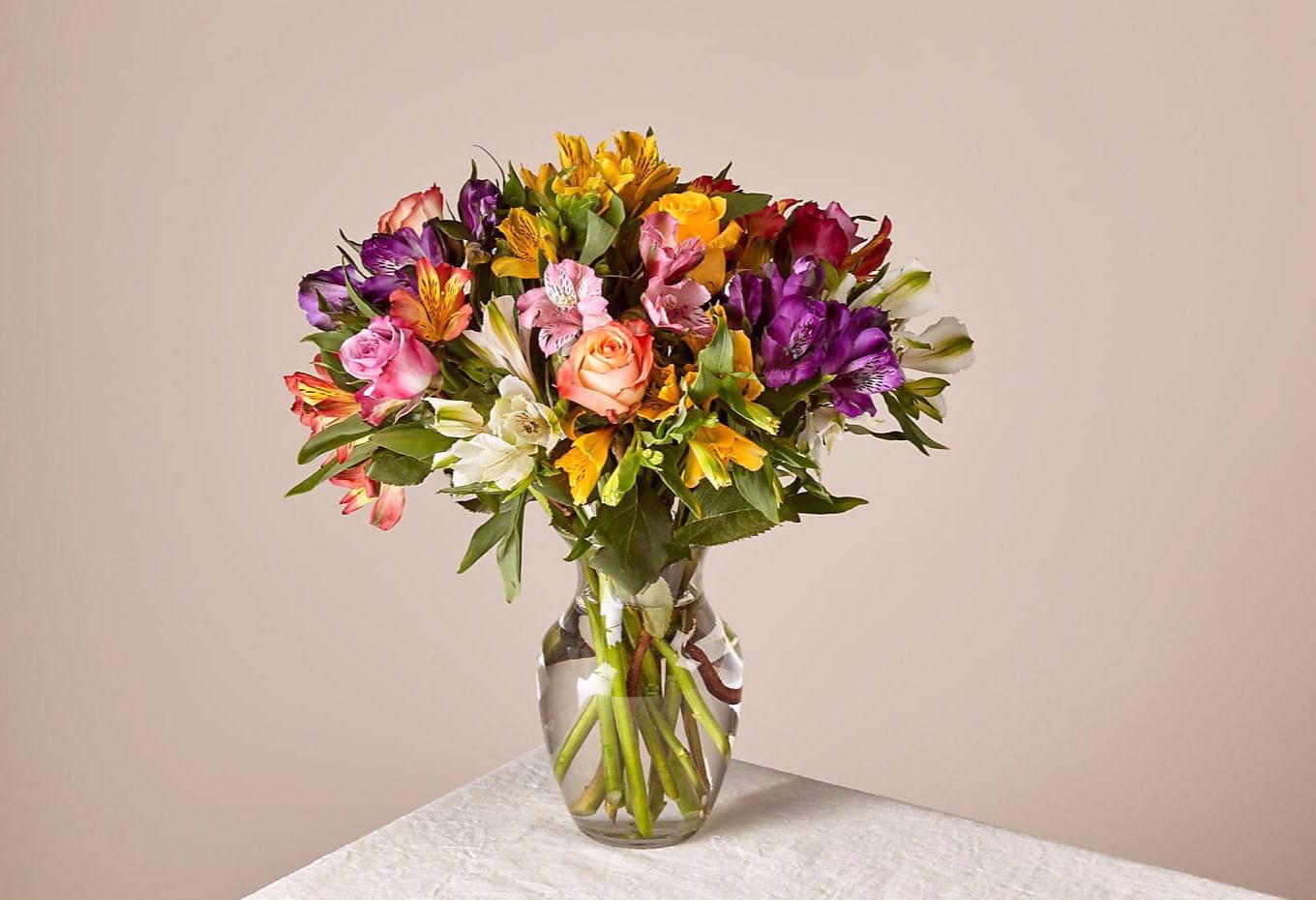 Mixed bouquet of colorful flowers in a clear glass vase